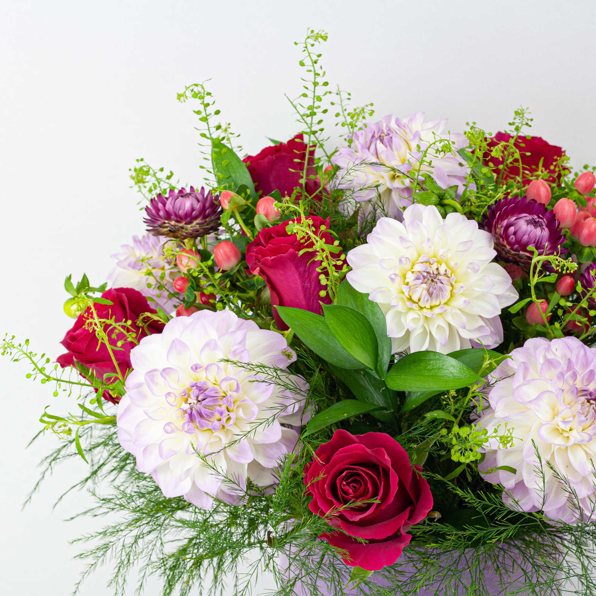 Bouquet of red roses and pale dahlias with green filler