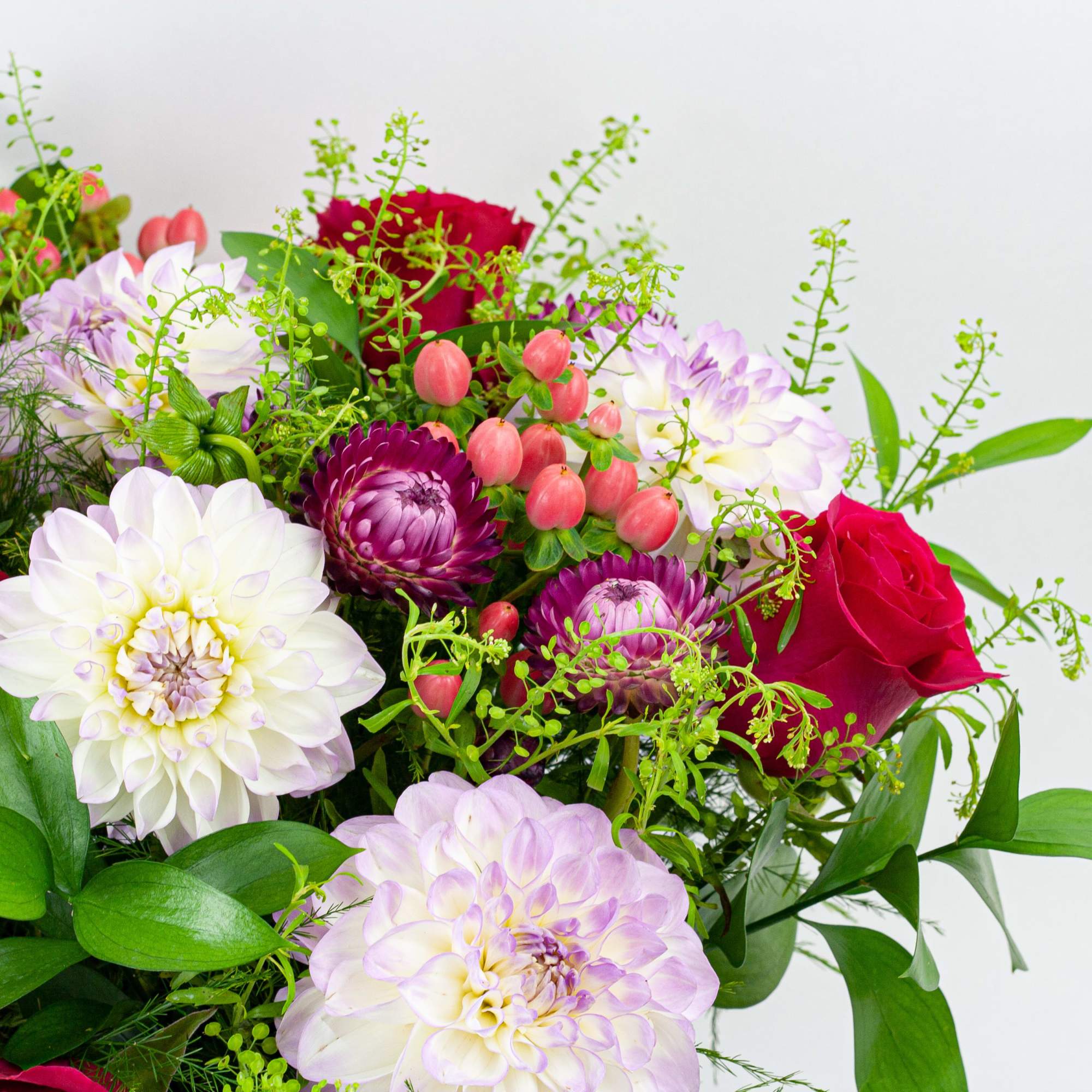 Bouquet of red roses and white dahlias with pink berries