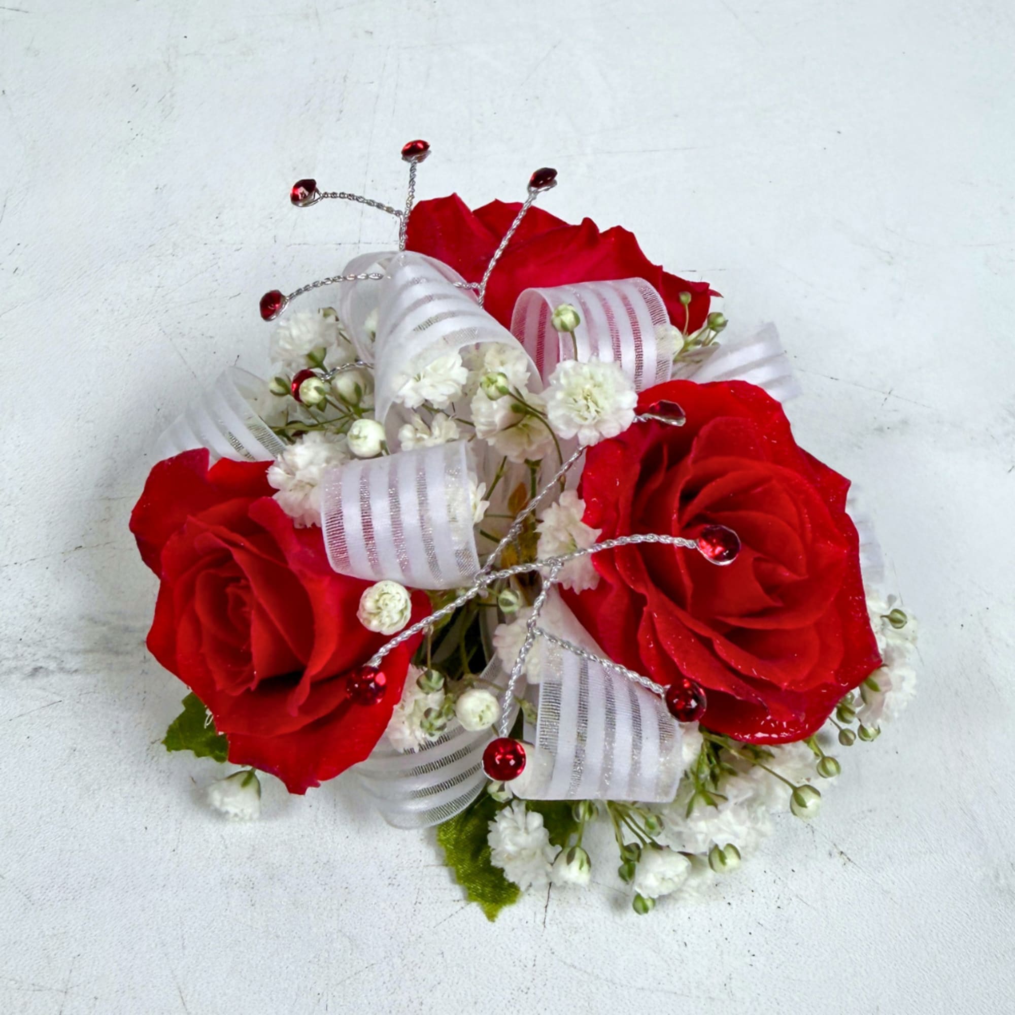 3 petite, classy red spray roses form a delicate, wearable cluster in