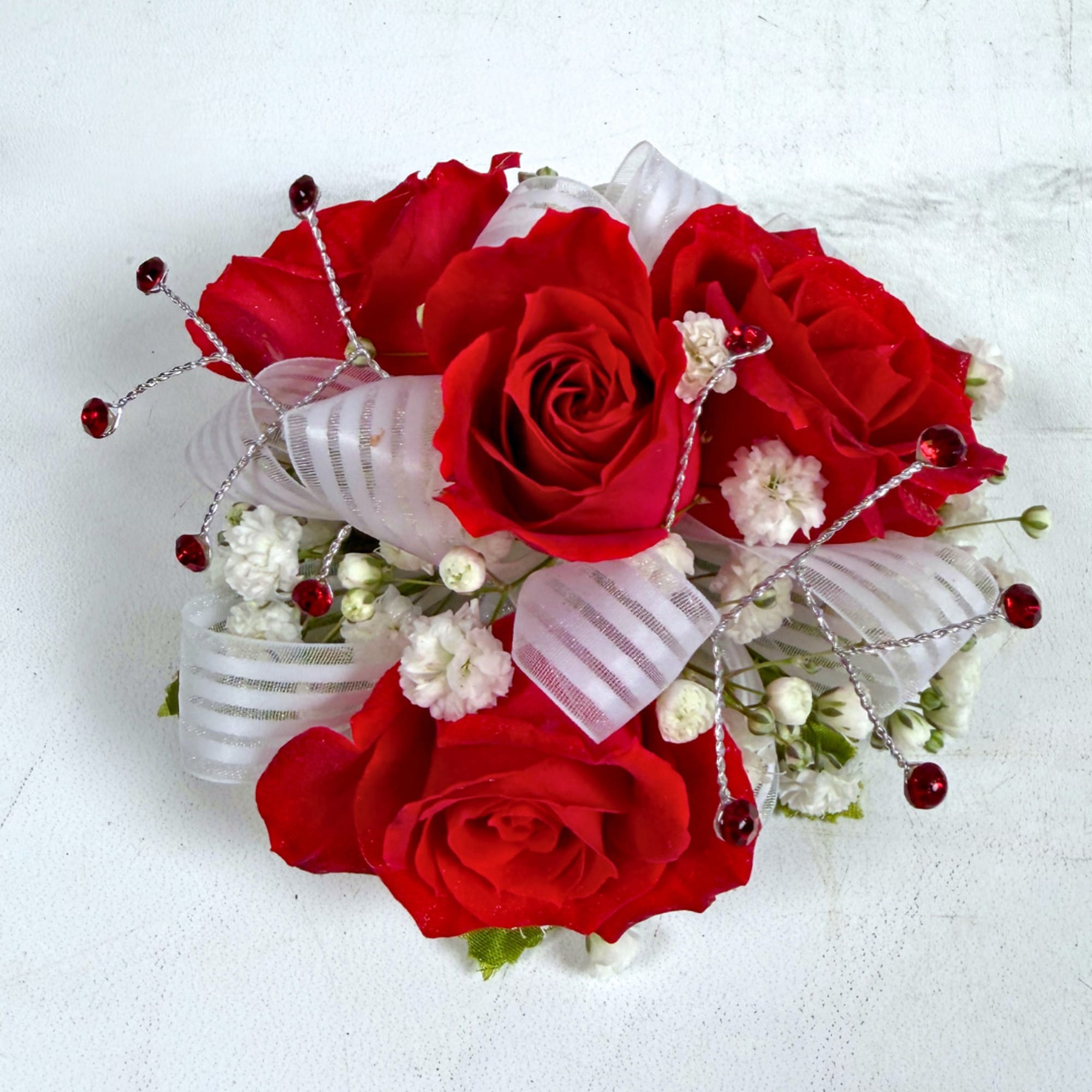 4 petite, classy red spray roses form a delicate, wearable cluster in