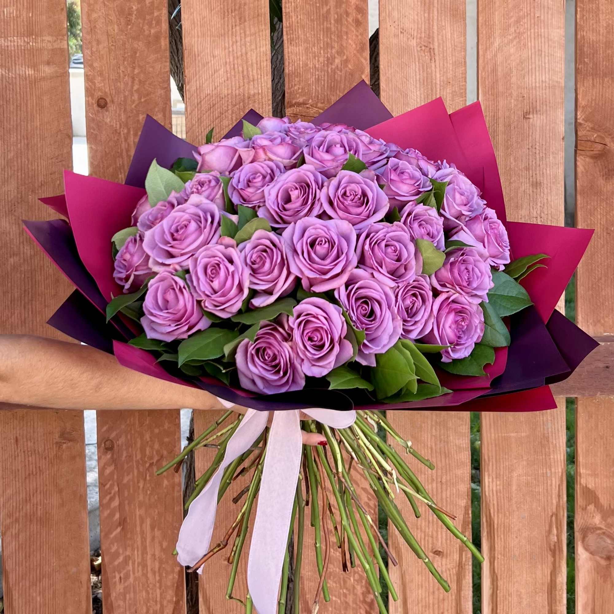 Bouquet of lavender roses wrapped in purple and pink paper