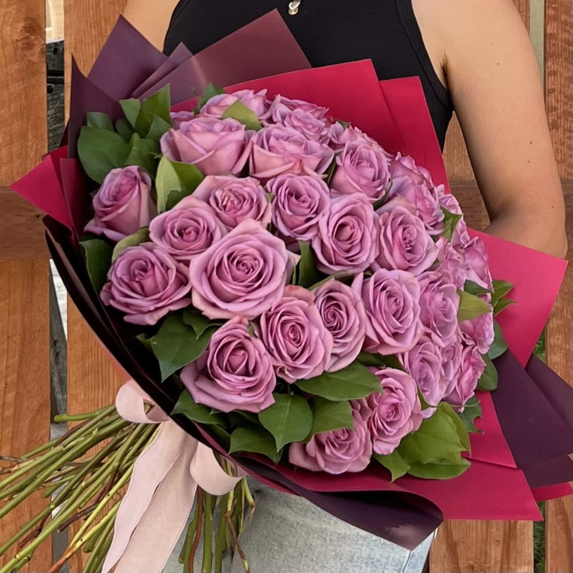 Bouquet of lavender roses wrapped in pink and purple paper