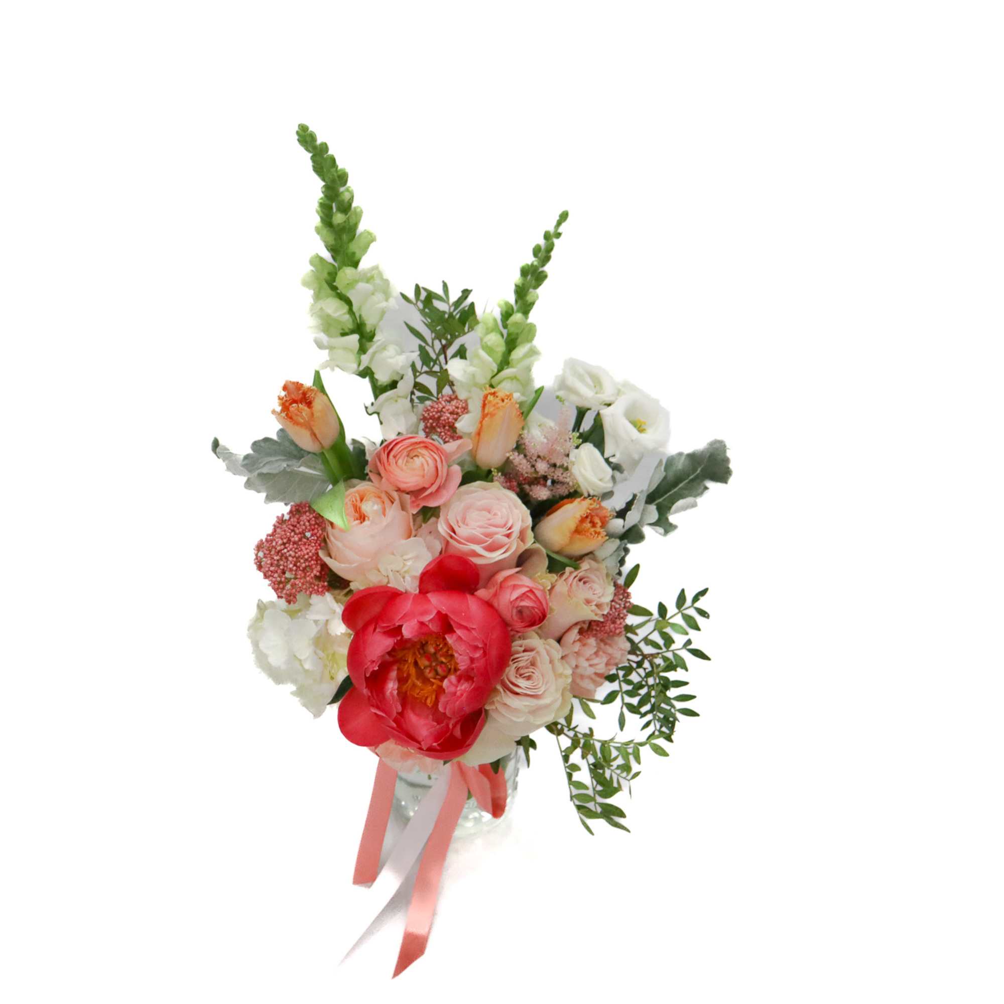 Mixed bouquet of pink, white, and red flowers in a clear vase