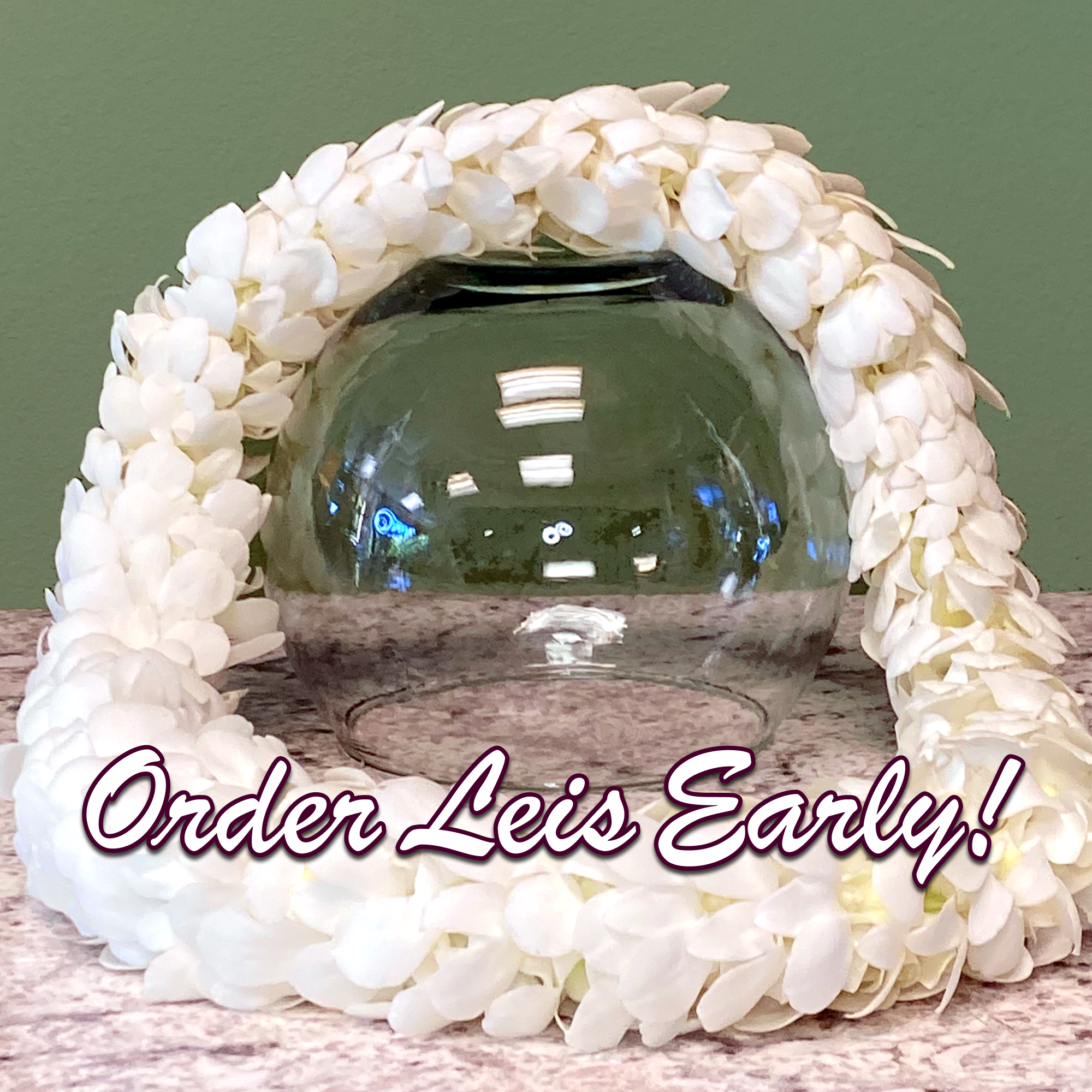 White floral garland draped around a clear glass bowl on a tabletop