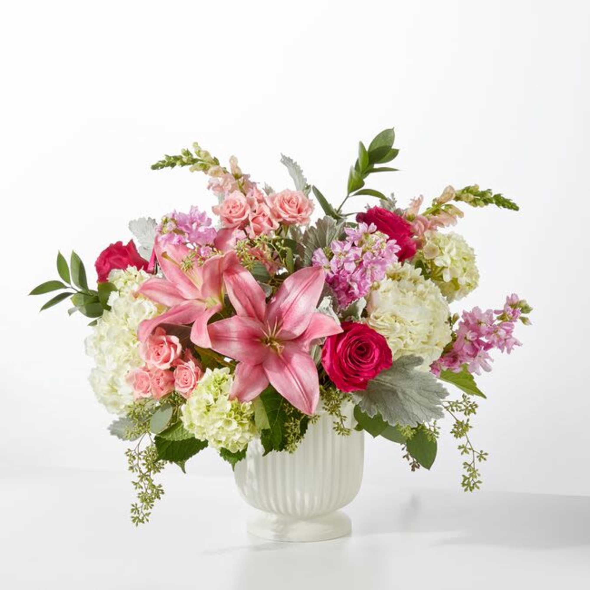 Pink lilies, roses, hydrangeas and lavender stock in a white ceramic vase-lush