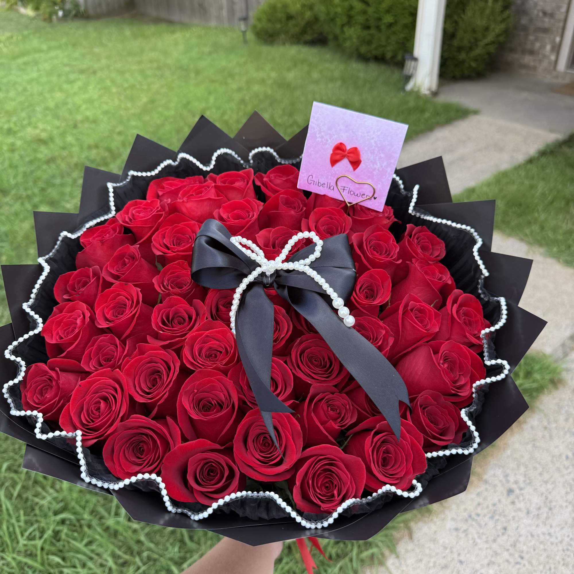 Bouquet of red roses wrapped in black paper with a black ribbon