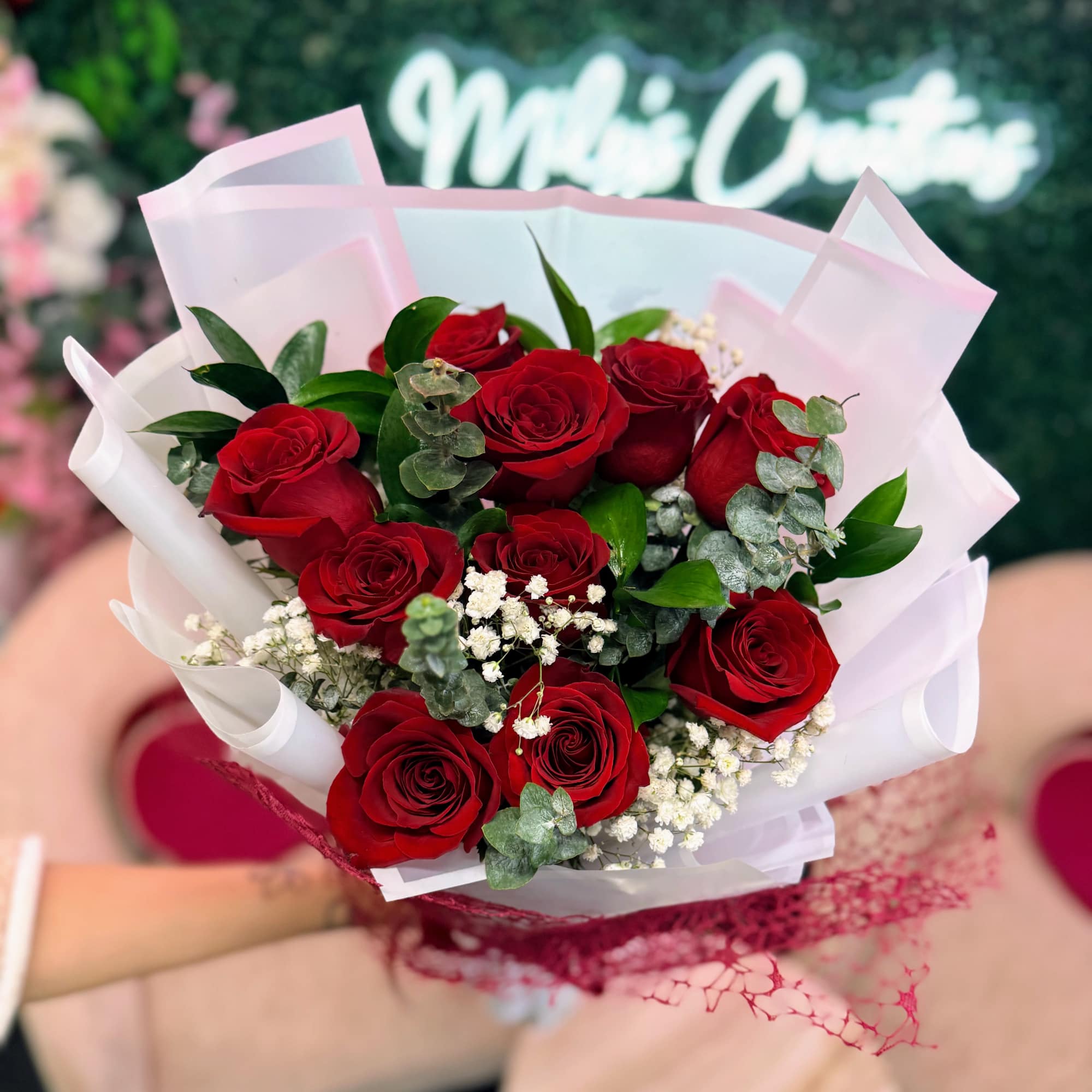 Bouquet of red roses wrapped in white and pink paper