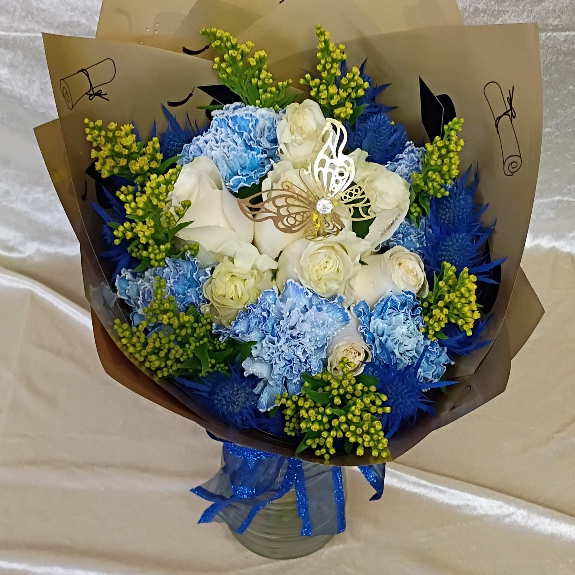 Crisp blue and white roses paired with pale blue carnations create a