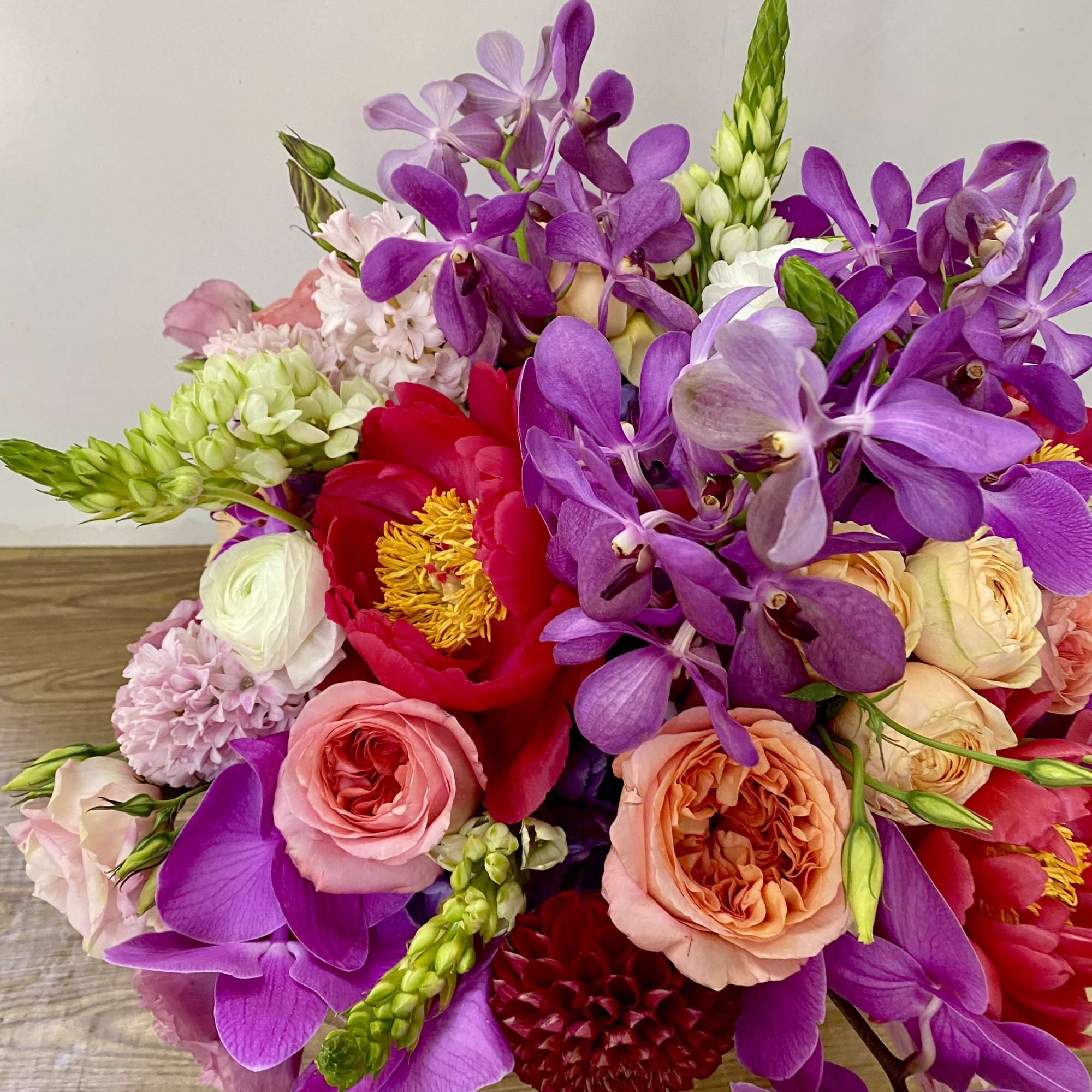 In a beautiful pink ceramic vase combination off pink roses, green hydrangeas