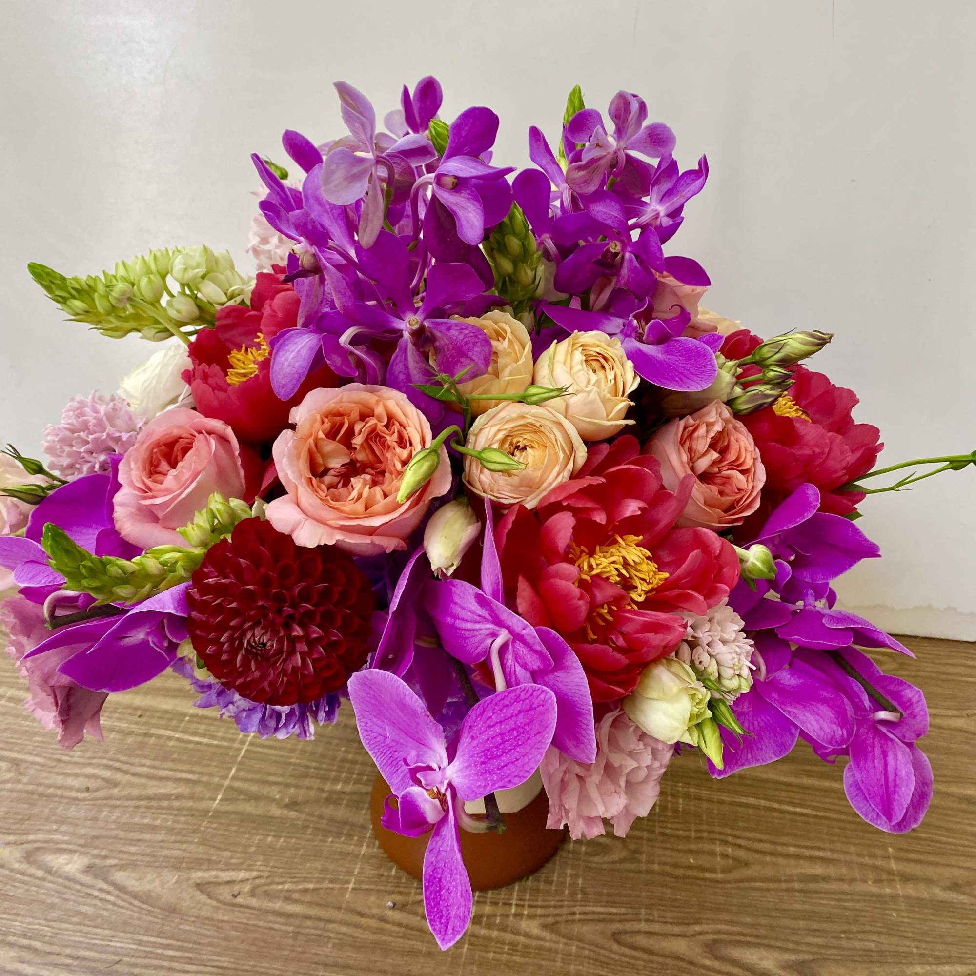 In a beautiful pink ceramic vase combination off pink roses, green hydrangeas