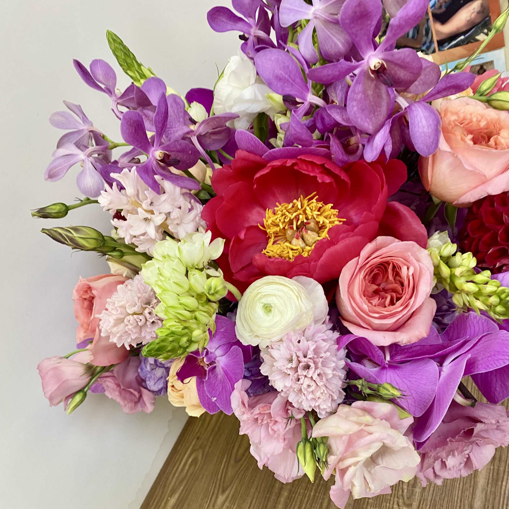 In a beautiful pink ceramic vase combination off pink roses, green hydrangeas