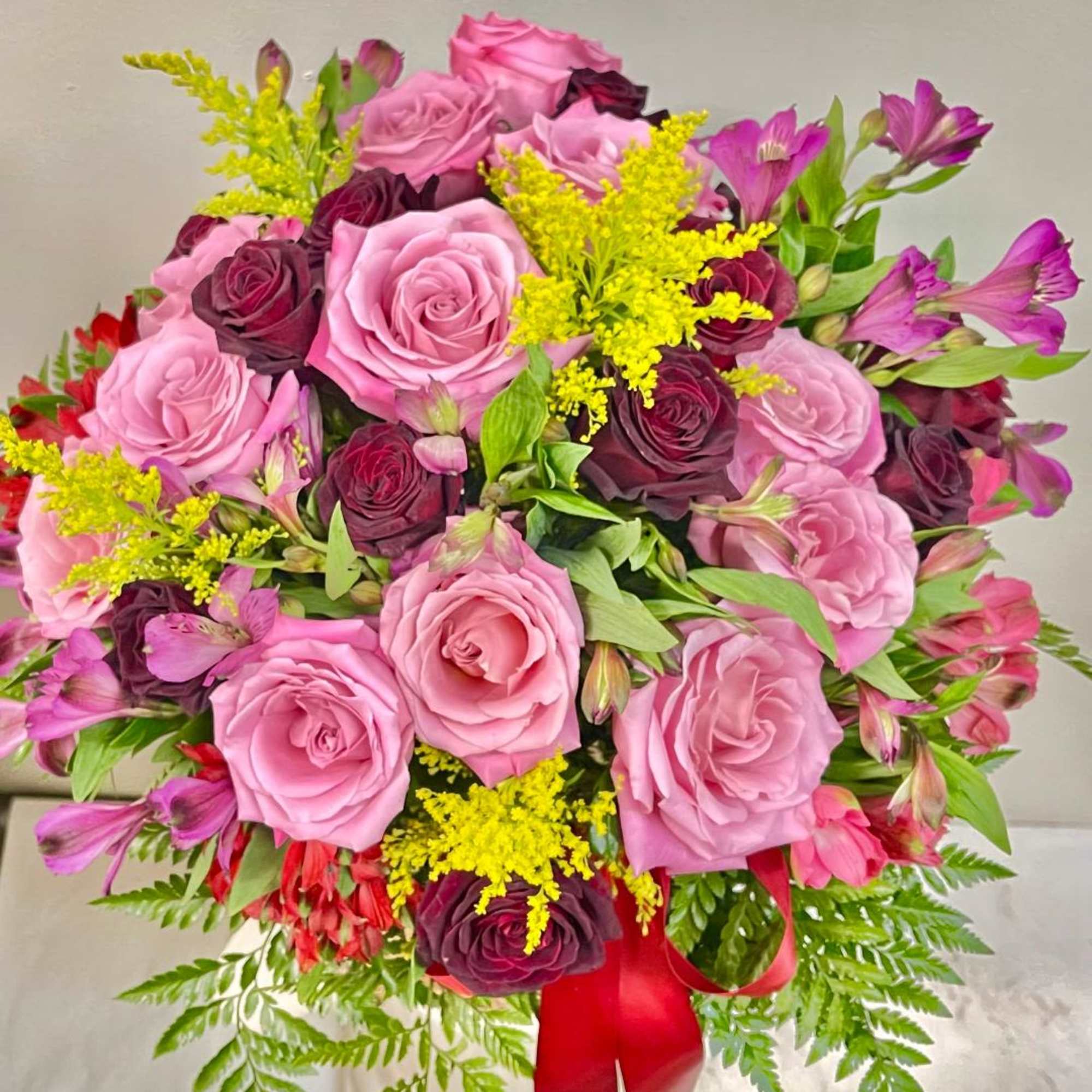 Pink and burgundy rose bouquet with yellow filler flowers