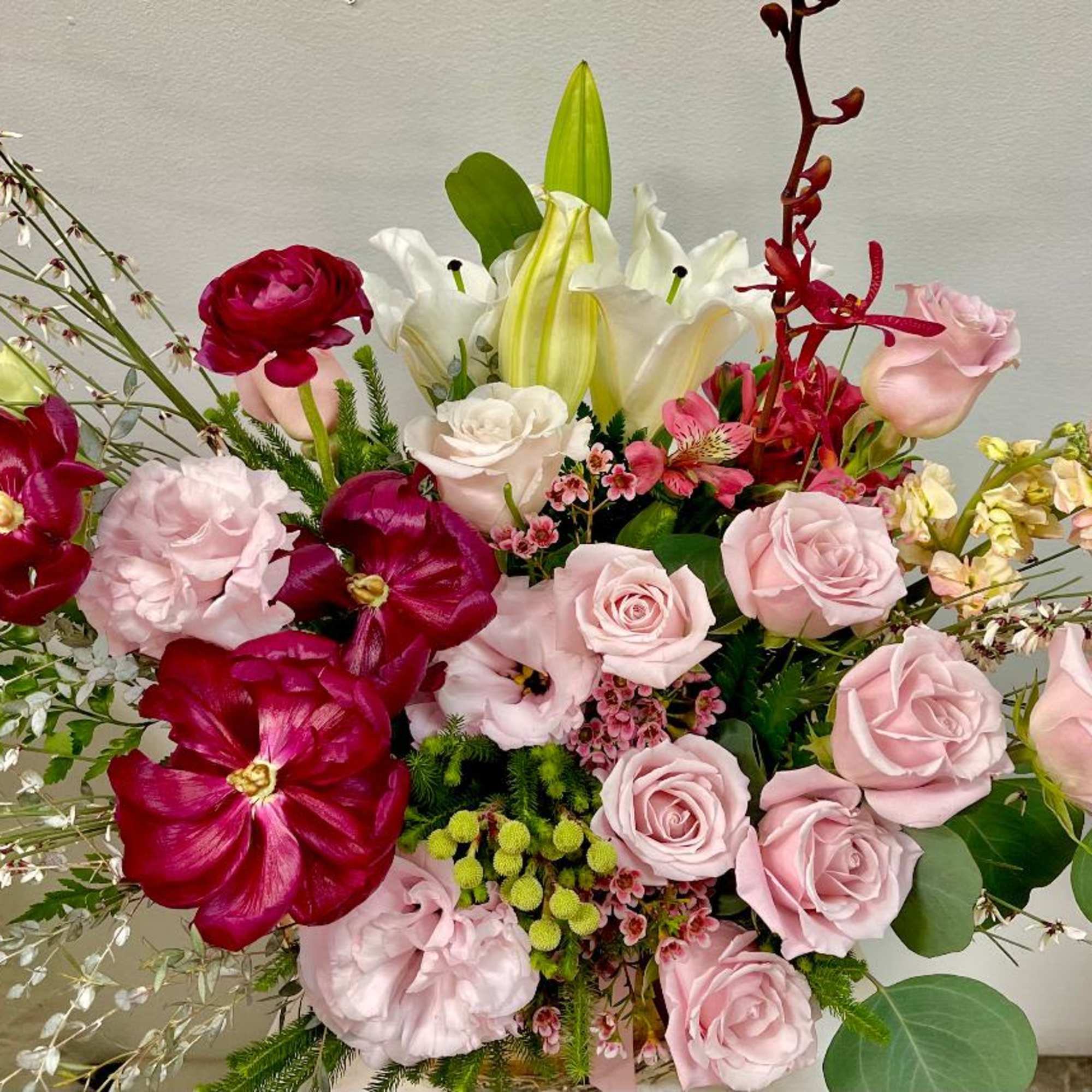 Bouquet of pink and red roses with white lilies and orchids