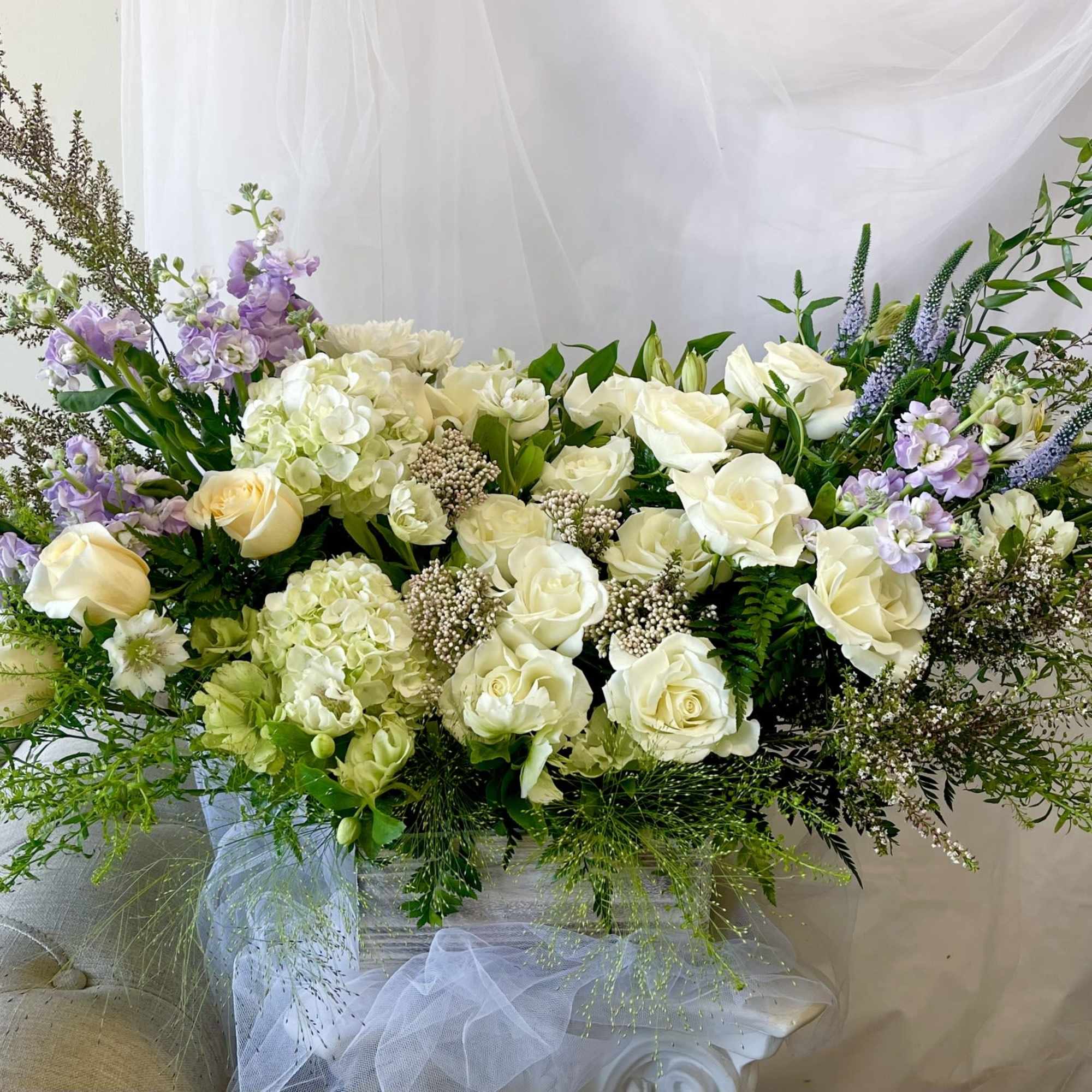 Large white and lavender floral arrangement in a vase