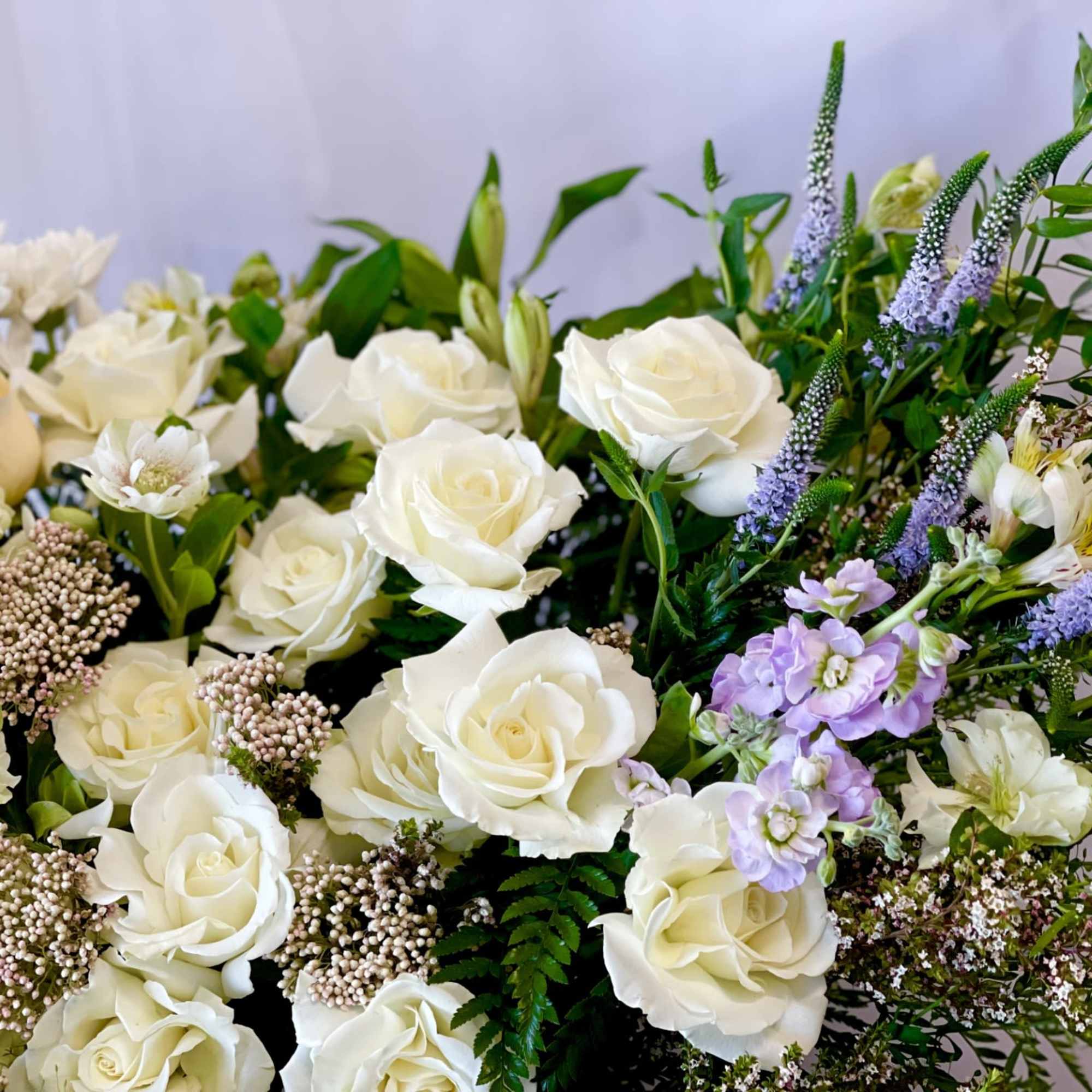White roses and pale purple flowers in a mixed bouquet