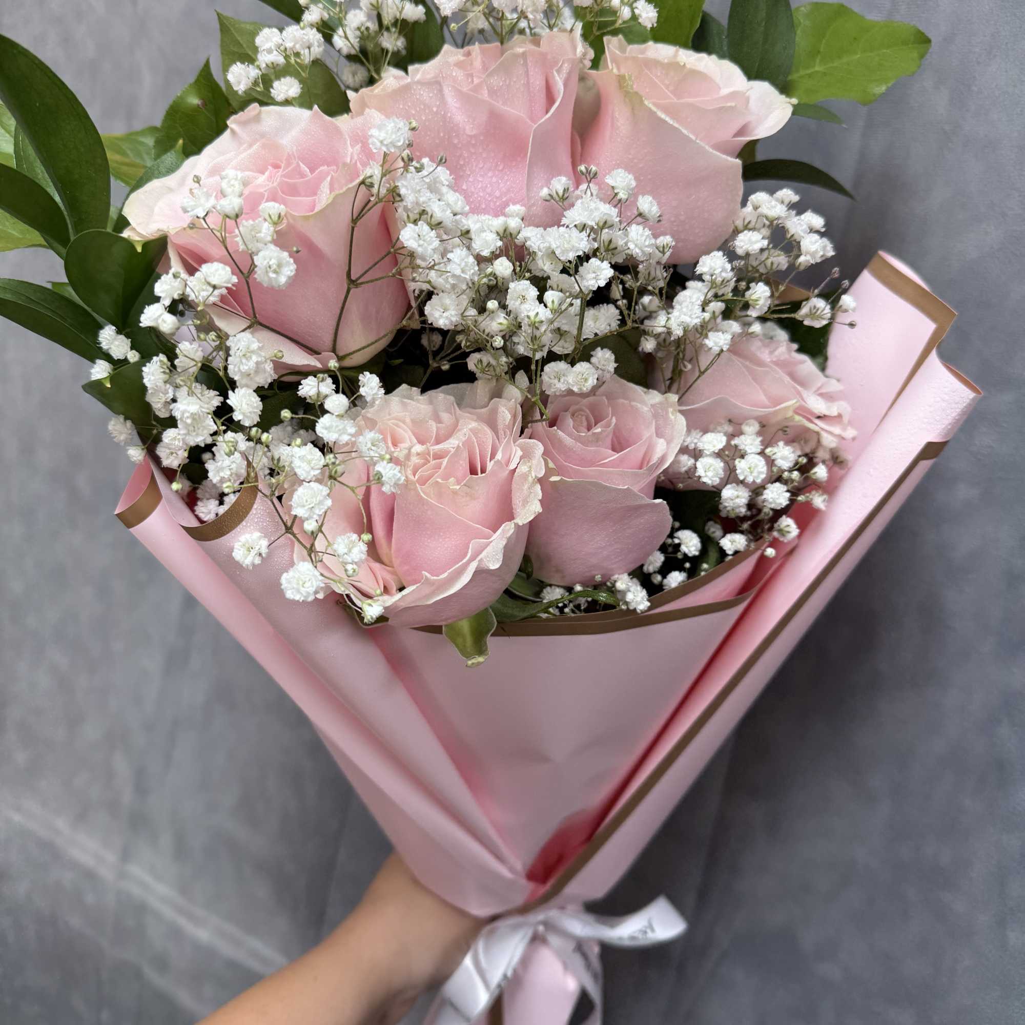 Pink roses with white baby's breath in pink wrapping