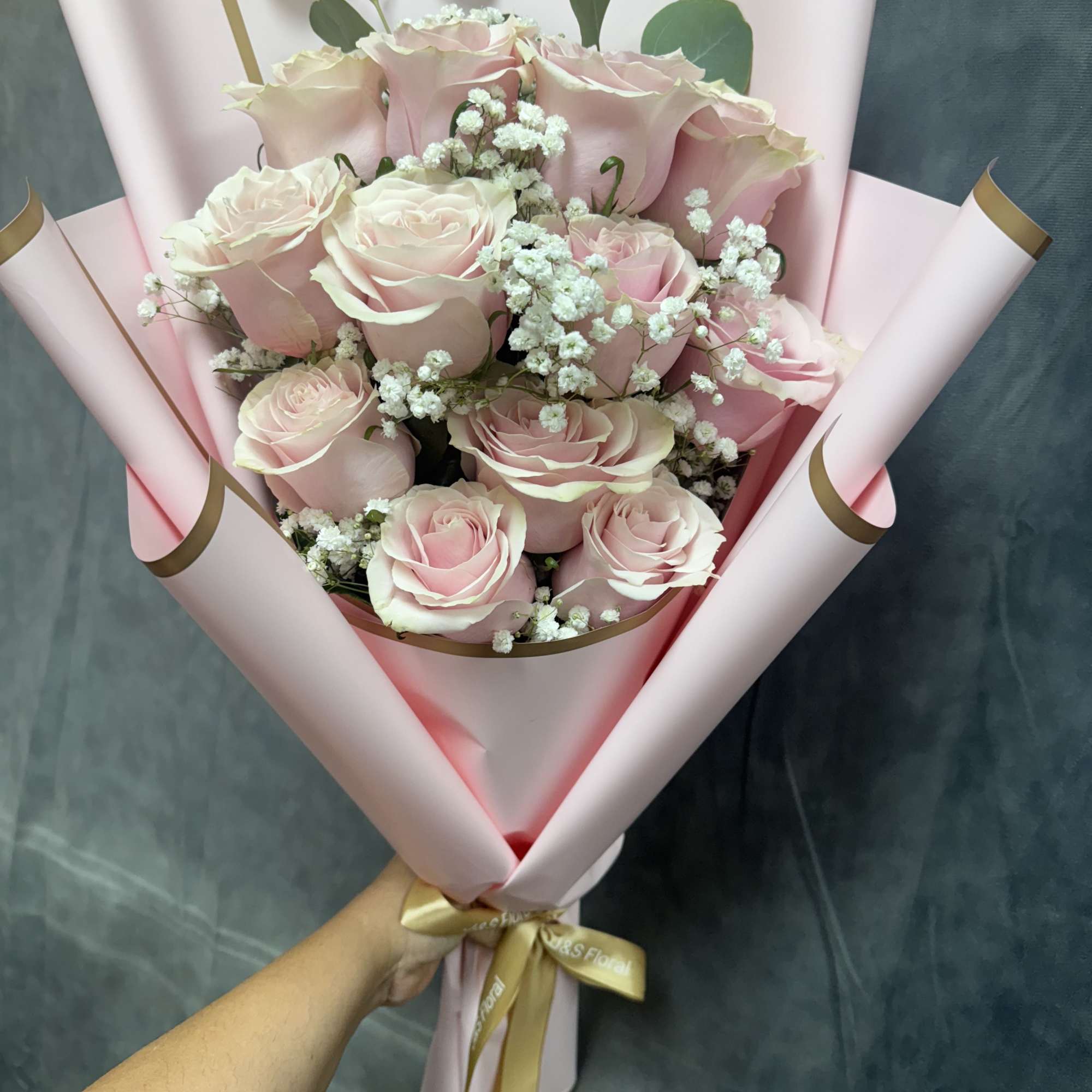 Pink rose bouquet with baby's breath in pastel wrapping