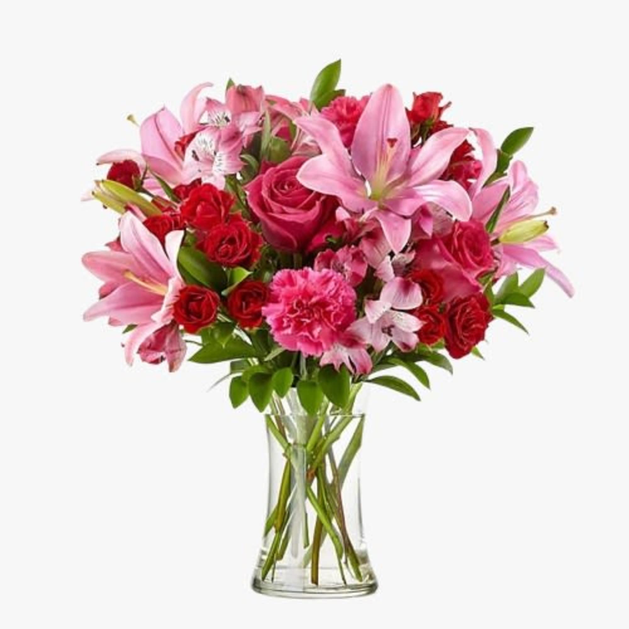 Pink lilies and red roses arranged in a clear glass vase