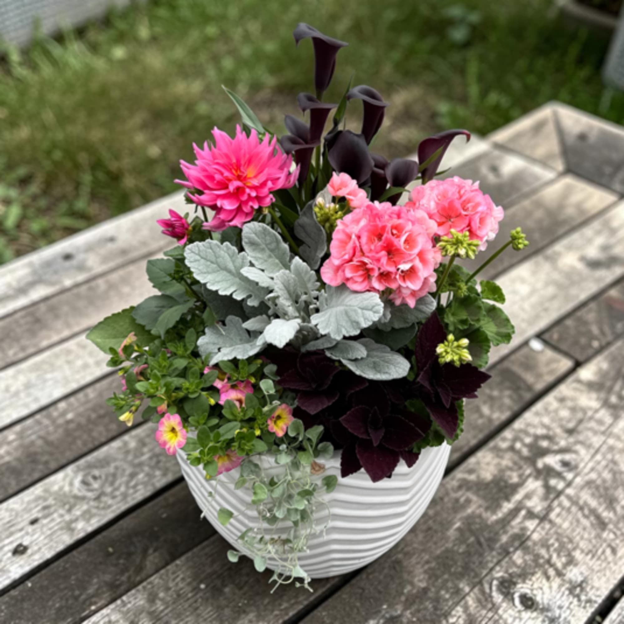 Bright hot-pink chrysanthemums and jewel-toned purple calla lilies create an immediate sunny