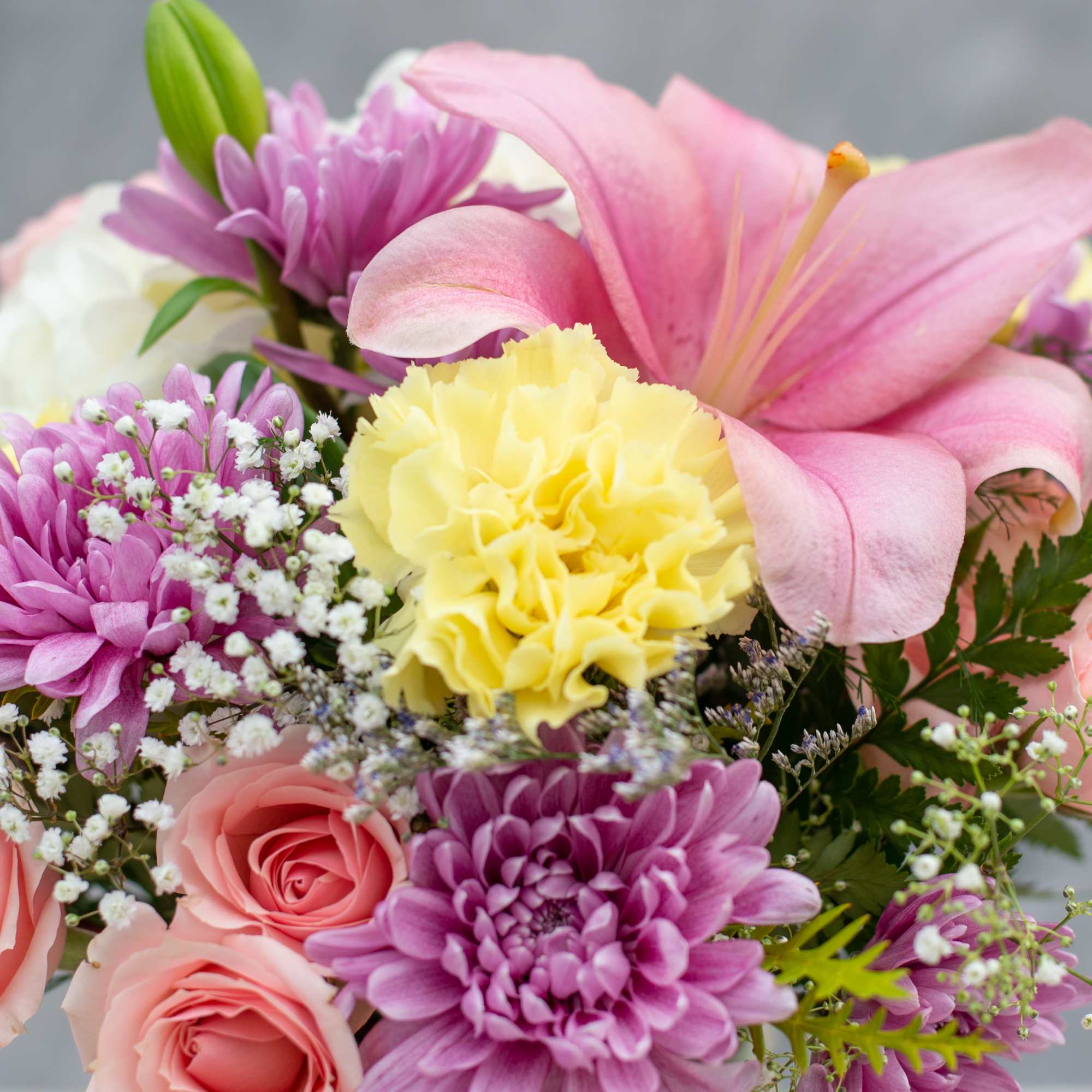 Bouquet of pink lilies, roses, carnations, and purple chrysanthemums