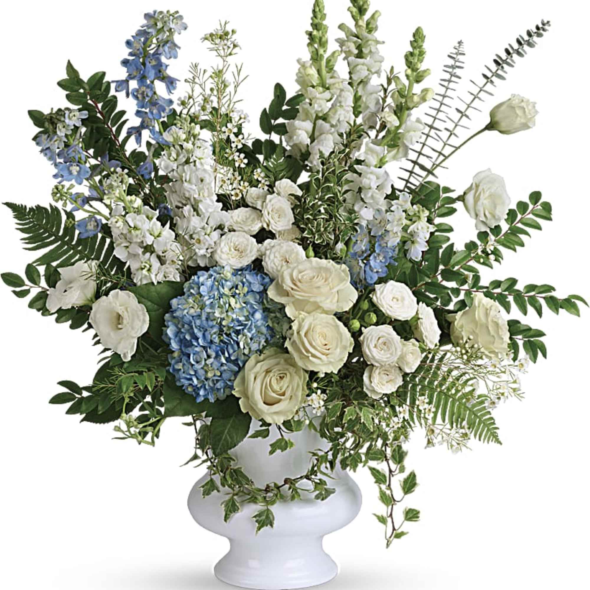 White and blue floral arrangement in a white pedestal vase