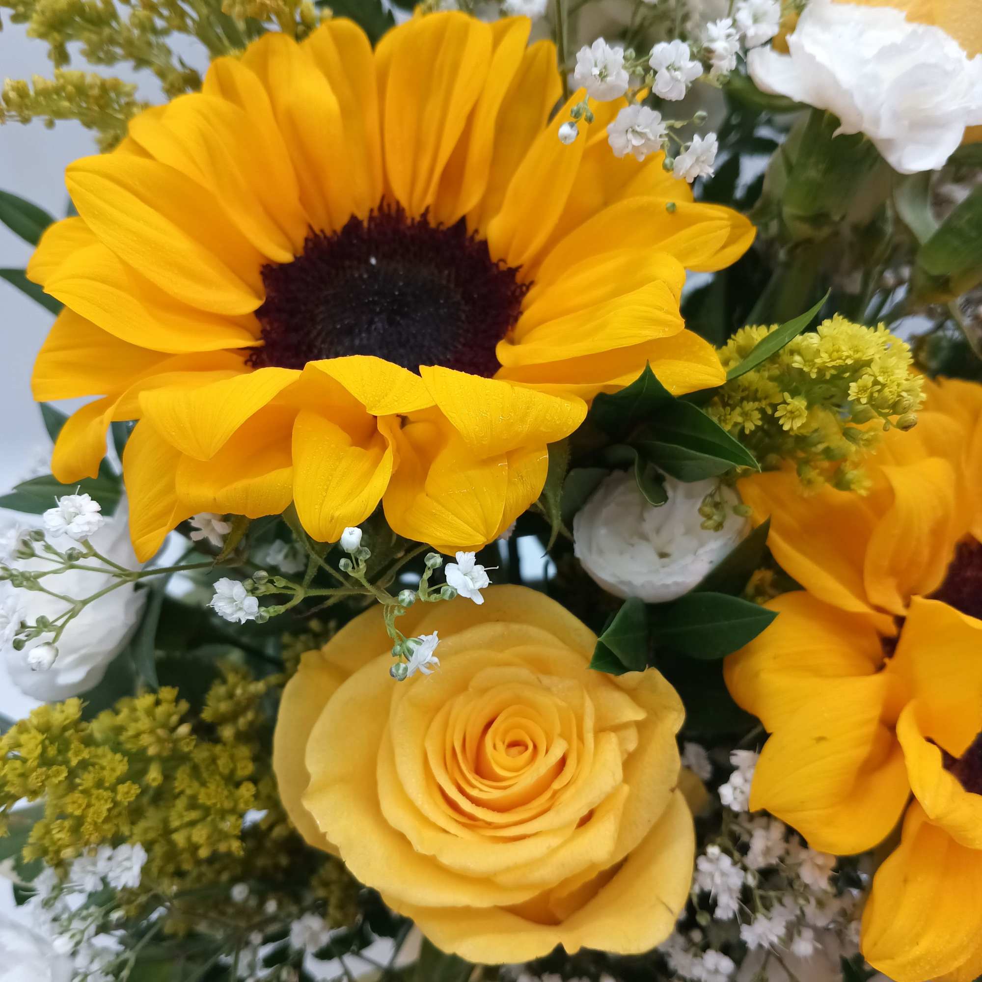 Yellow sunflowers and roses with white filler flowers