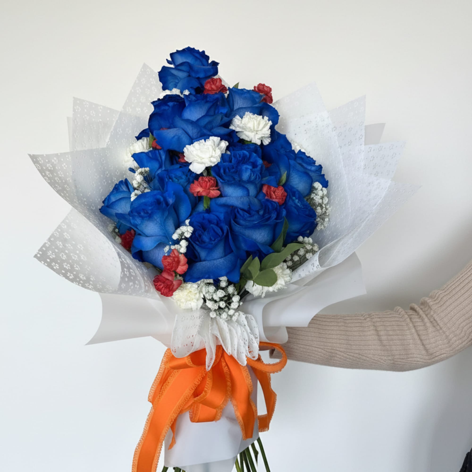 Vivid blue roses take center stage in this celebratory bouquet-a bold flower