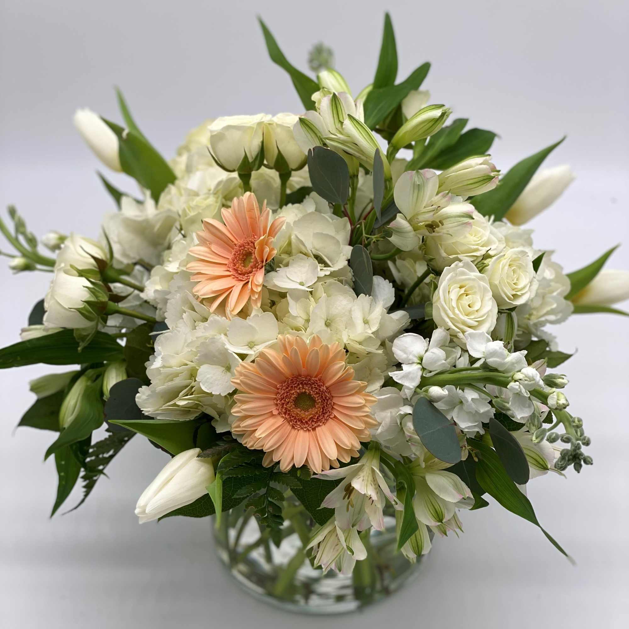 White and peach mixed bouquet in a glass vase