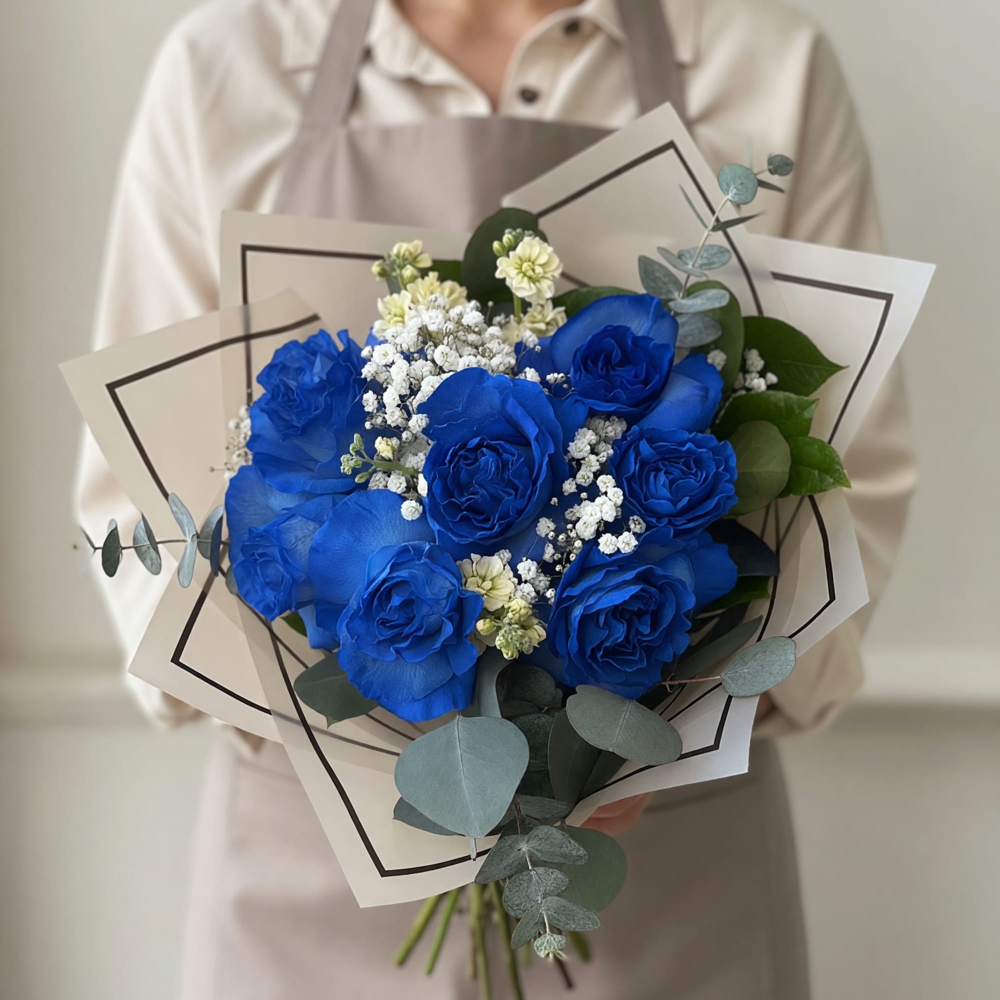 Vivid blue roses take center stage in this hand-tied flower arrangement, making