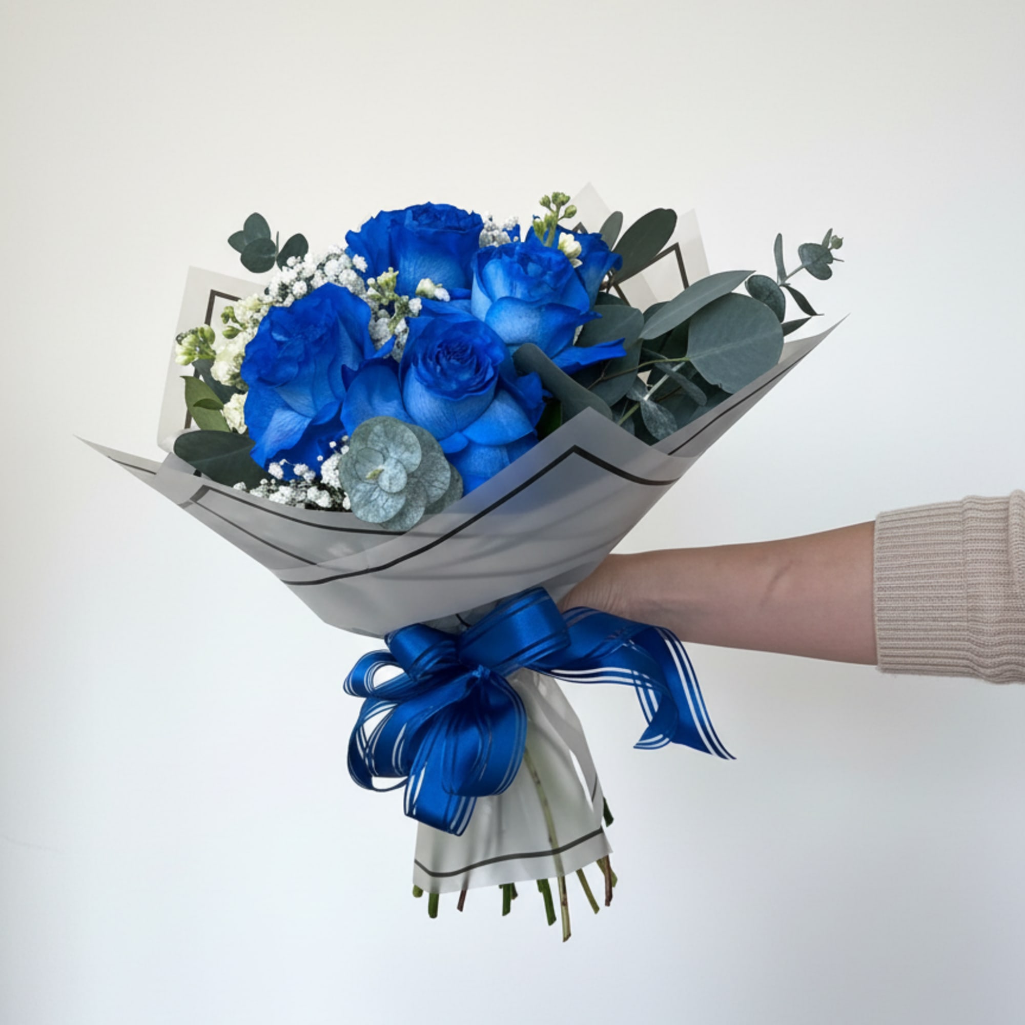 Vivid blue roses take center stage in this hand-tied flower arrangement, making