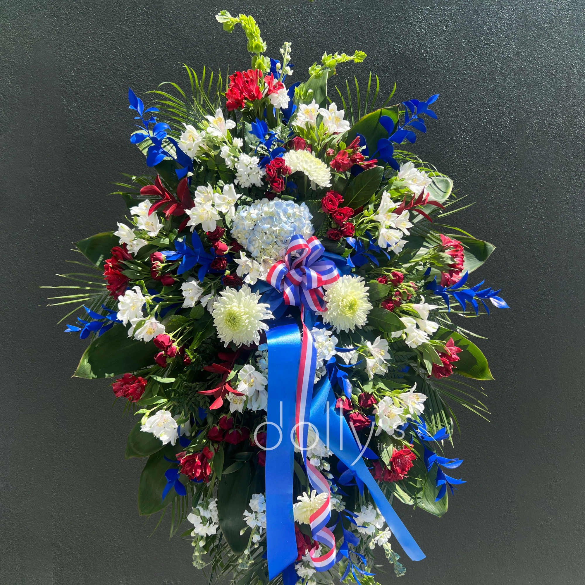 A commanding standing sympathy spray that honors a life with both patriotic