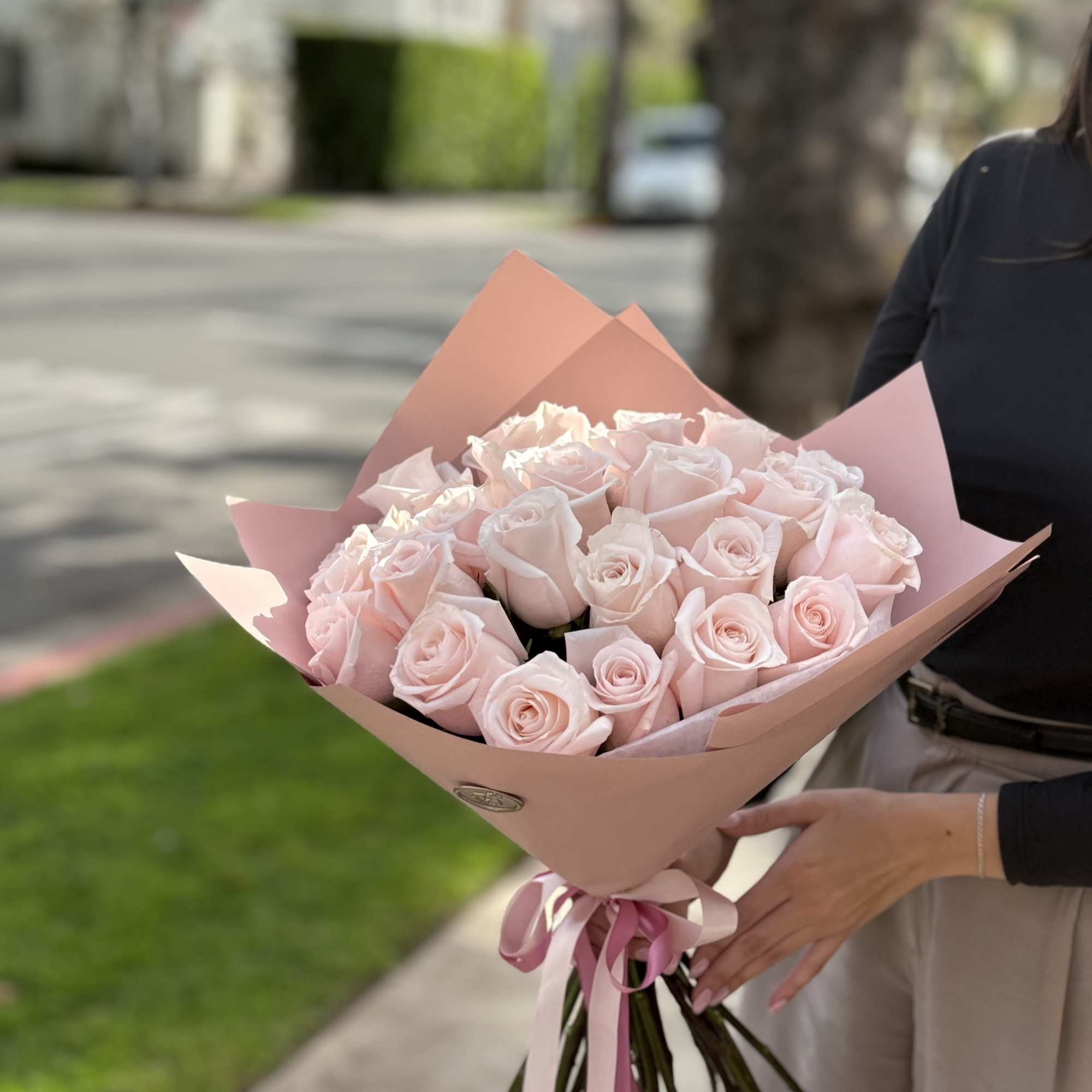 Bouquet of pale pink roses wrapped in pink paper