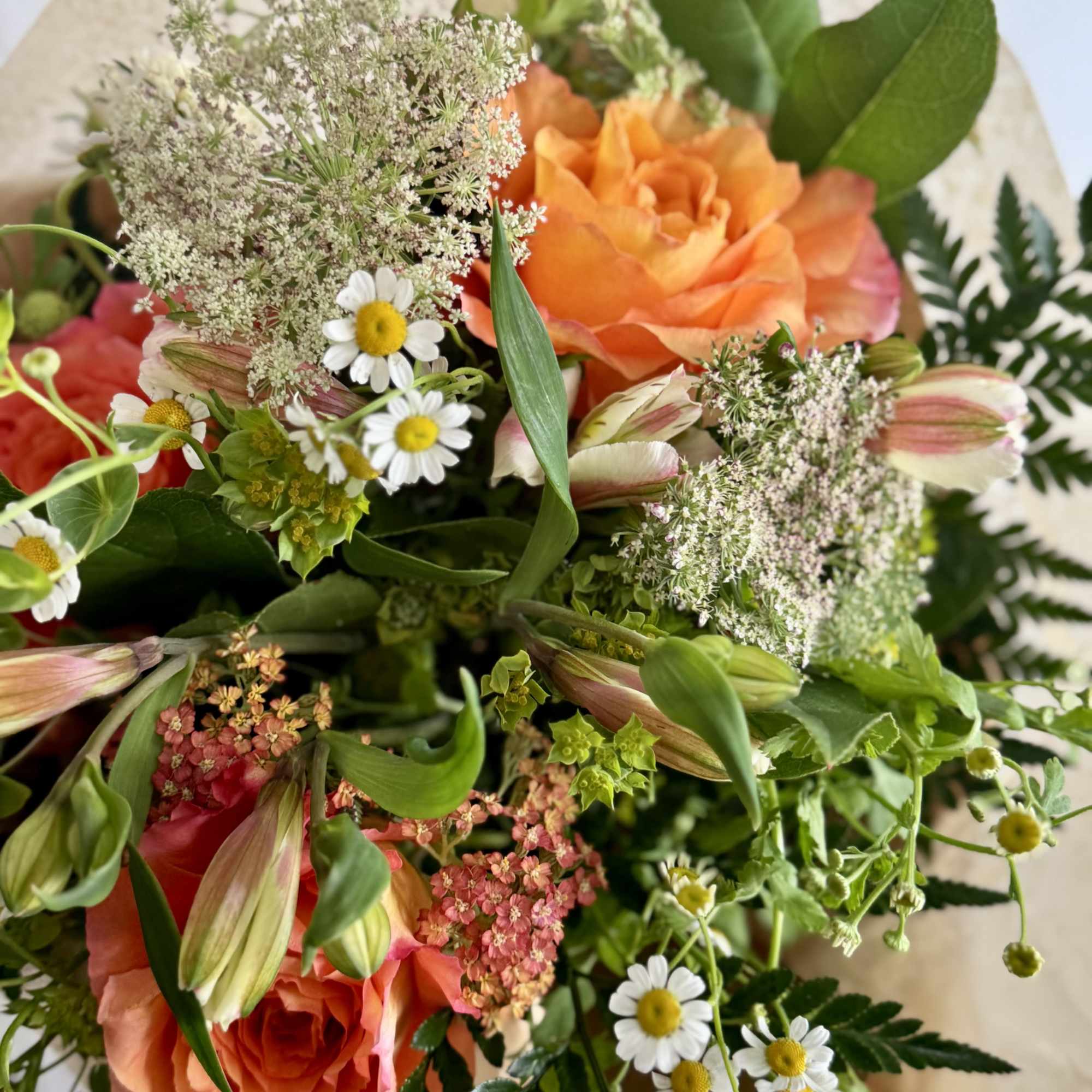 A burst of orange and soft pink-and-cream creates an instantly cheerful, hand-tied