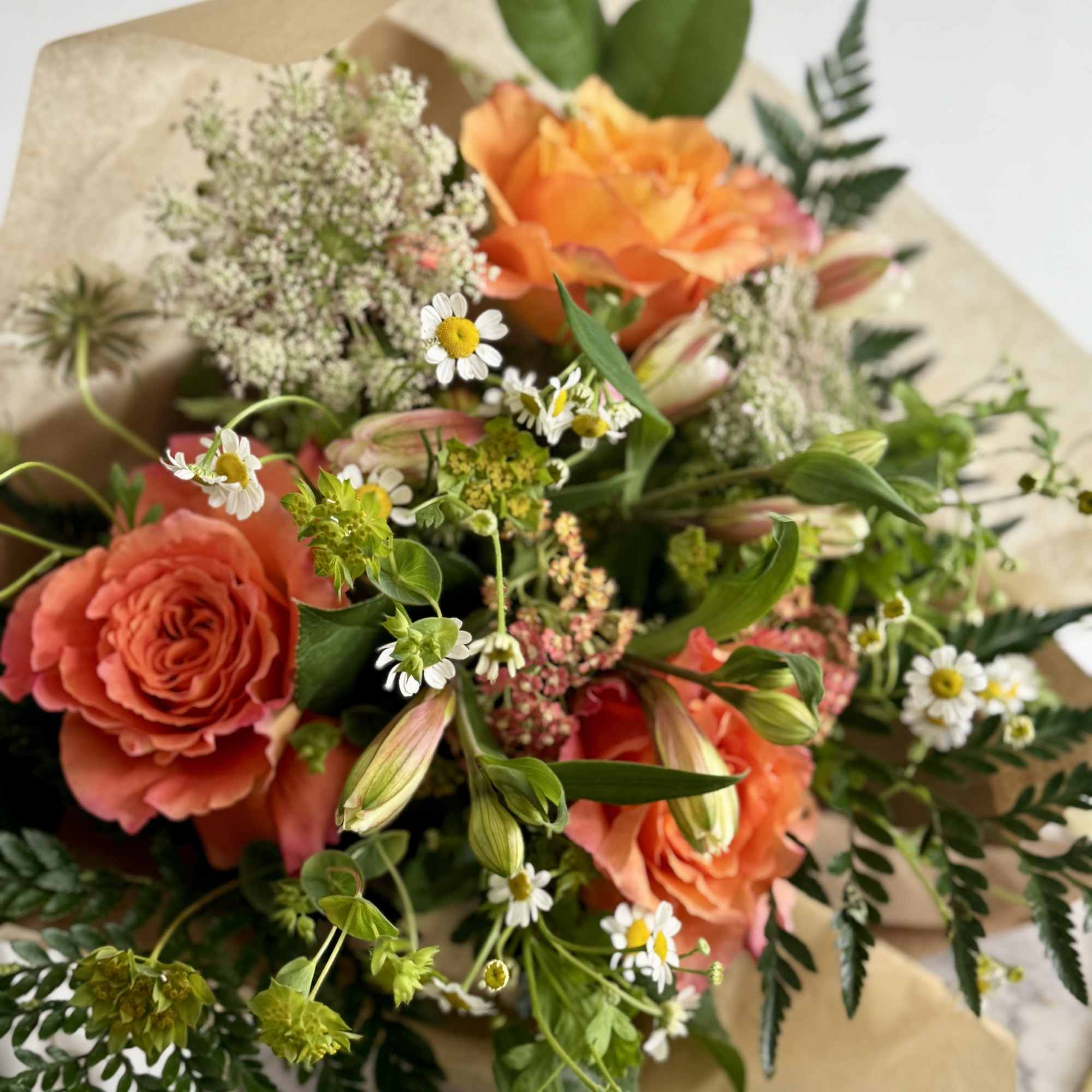 A burst of orange and soft pink-and-cream creates an instantly cheerful, hand-tied