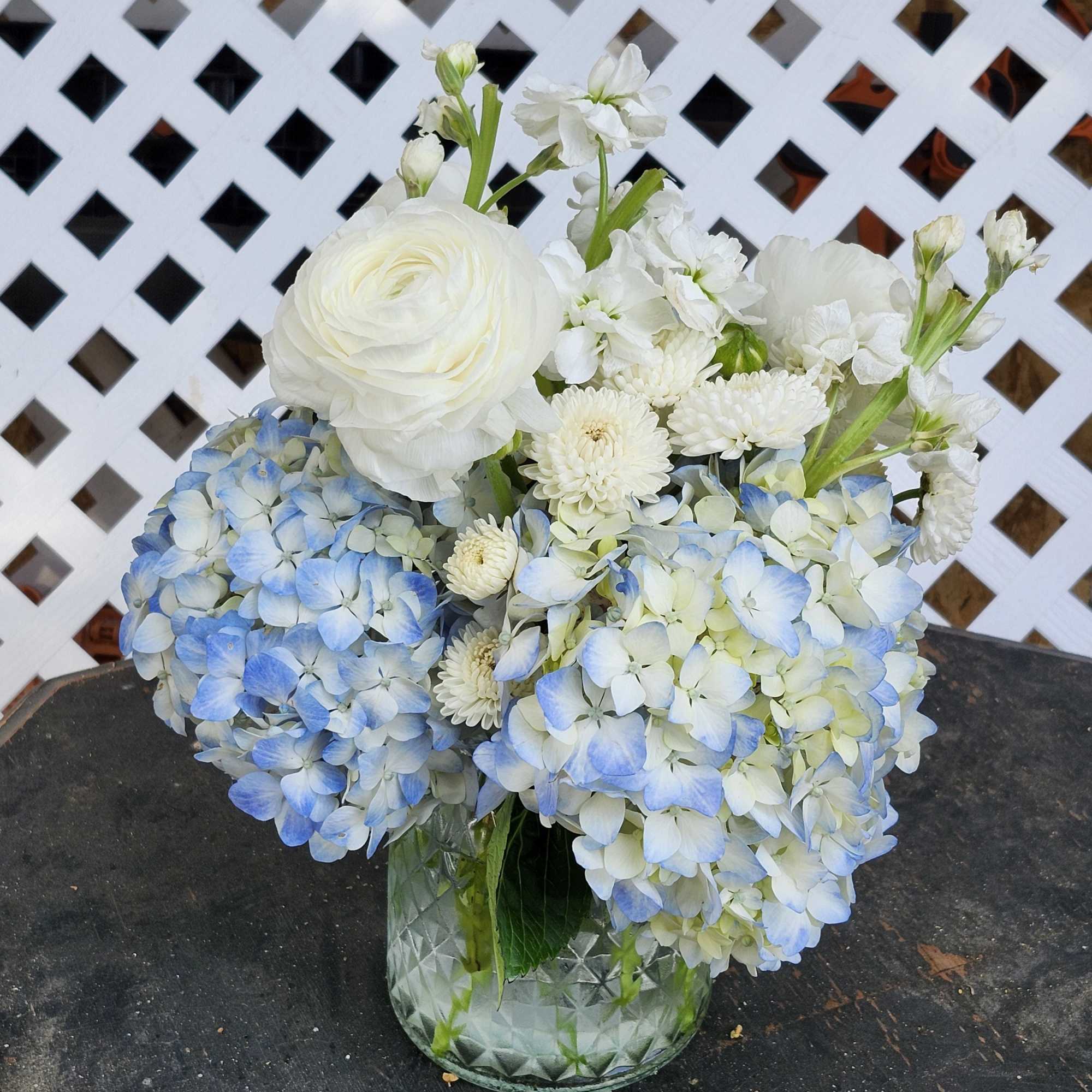 Blue and white flower arrangement in a glass vase