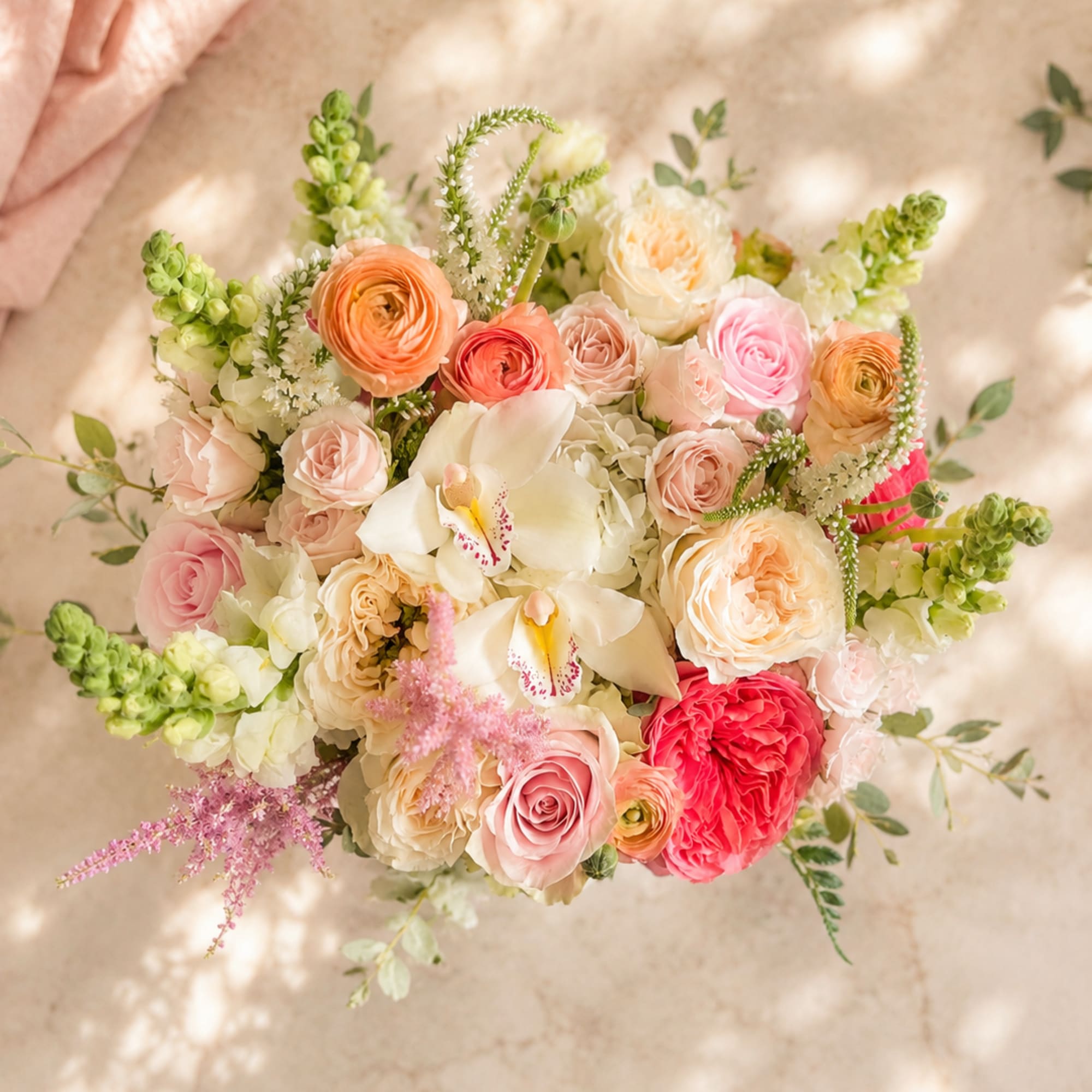 A white hatbox arrangement of white and pink flowers. Delicate just like