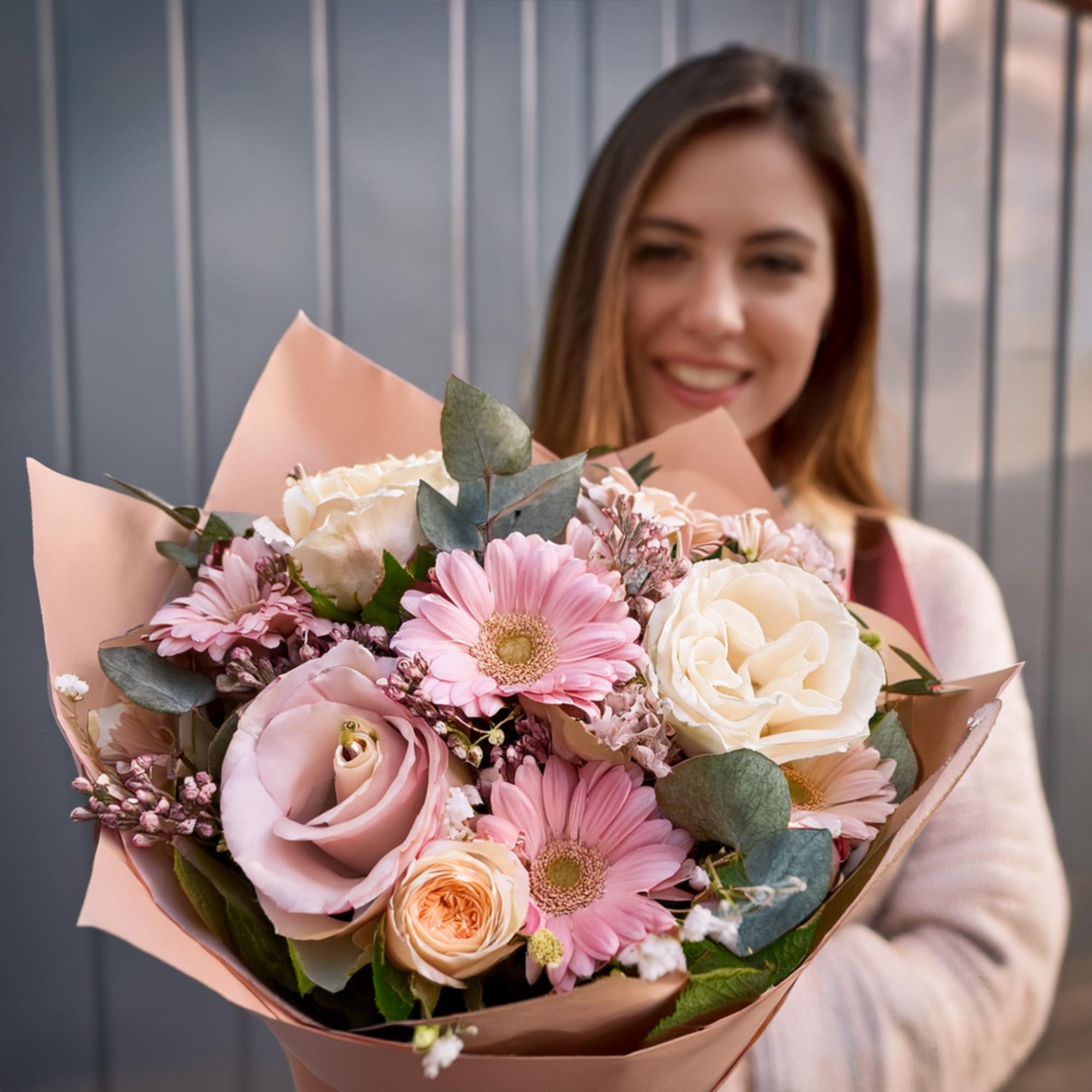 Pink and white bouquet with roses and daisies wrapped in blush paper