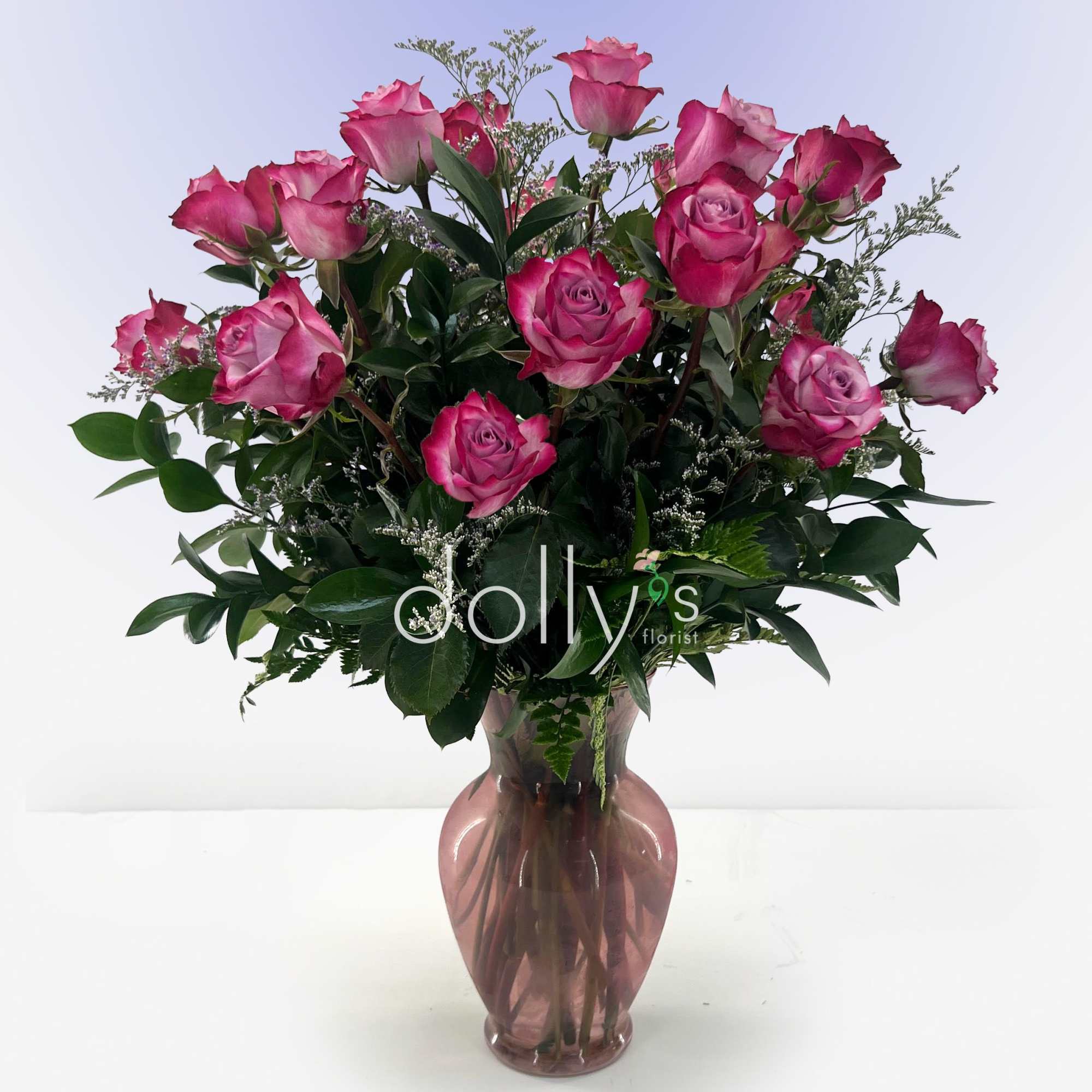 Pink roses arranged in a mauve glass vase