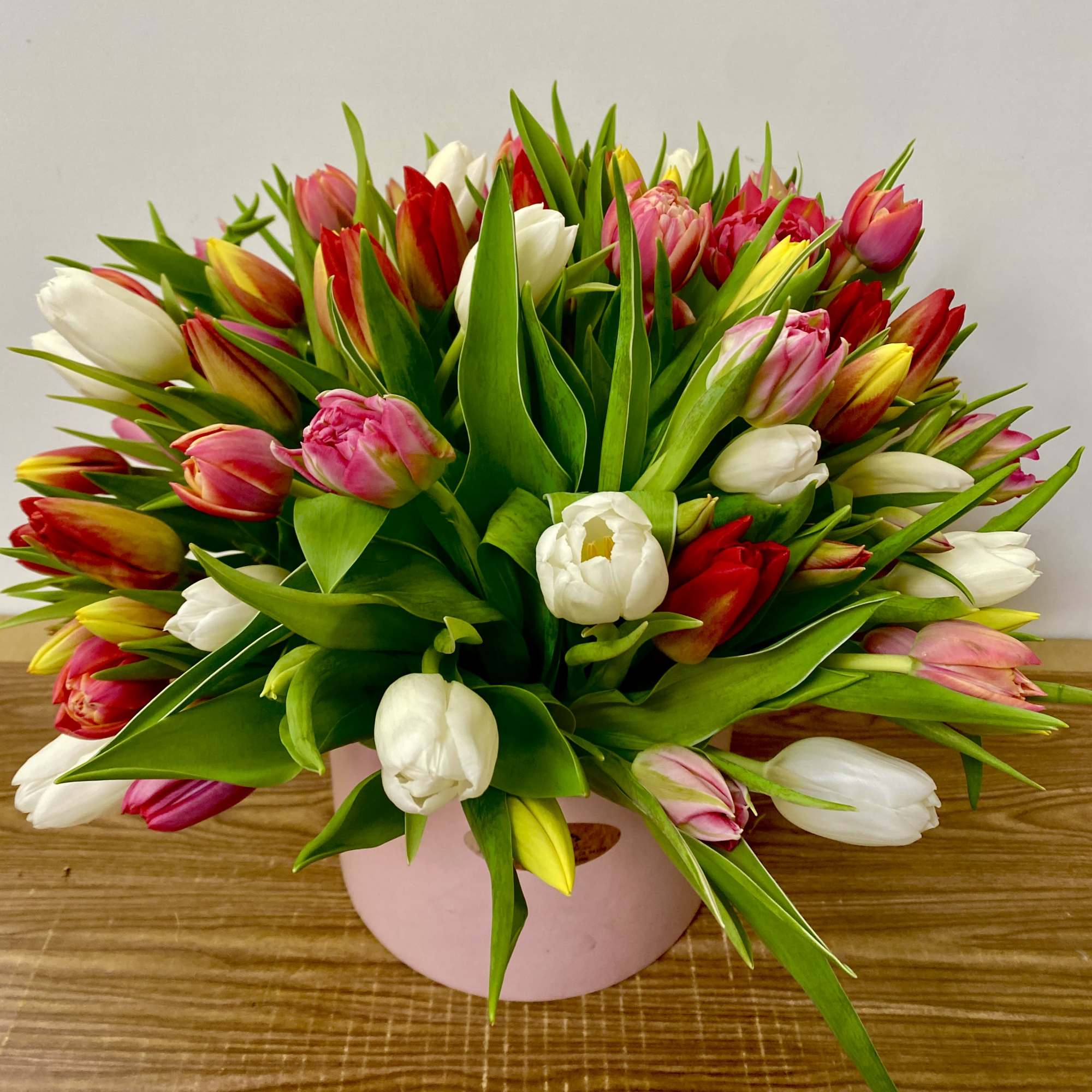 Mixed tulip bouquet in a pink round box