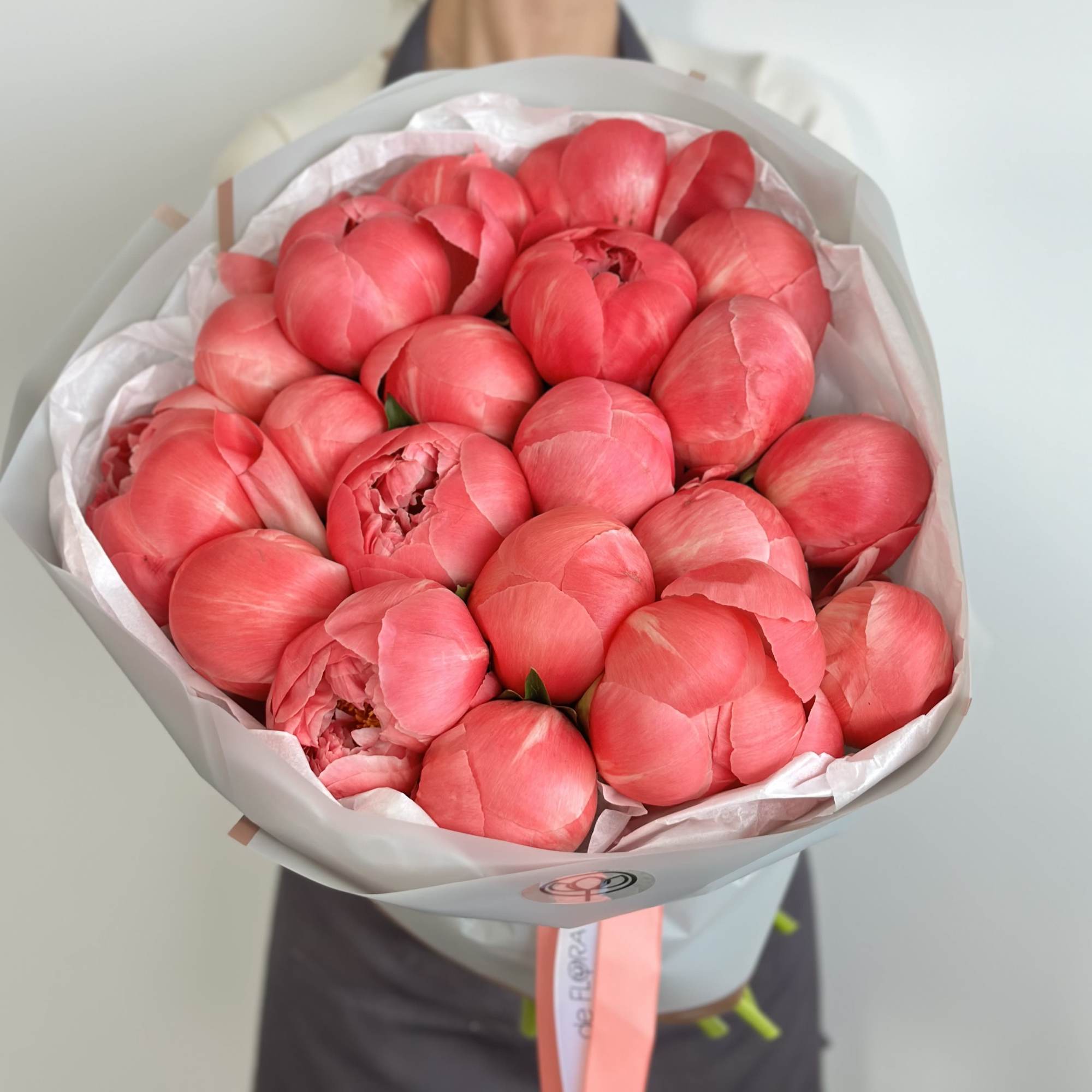 Bouquet of pink peonies wrapped in white paper