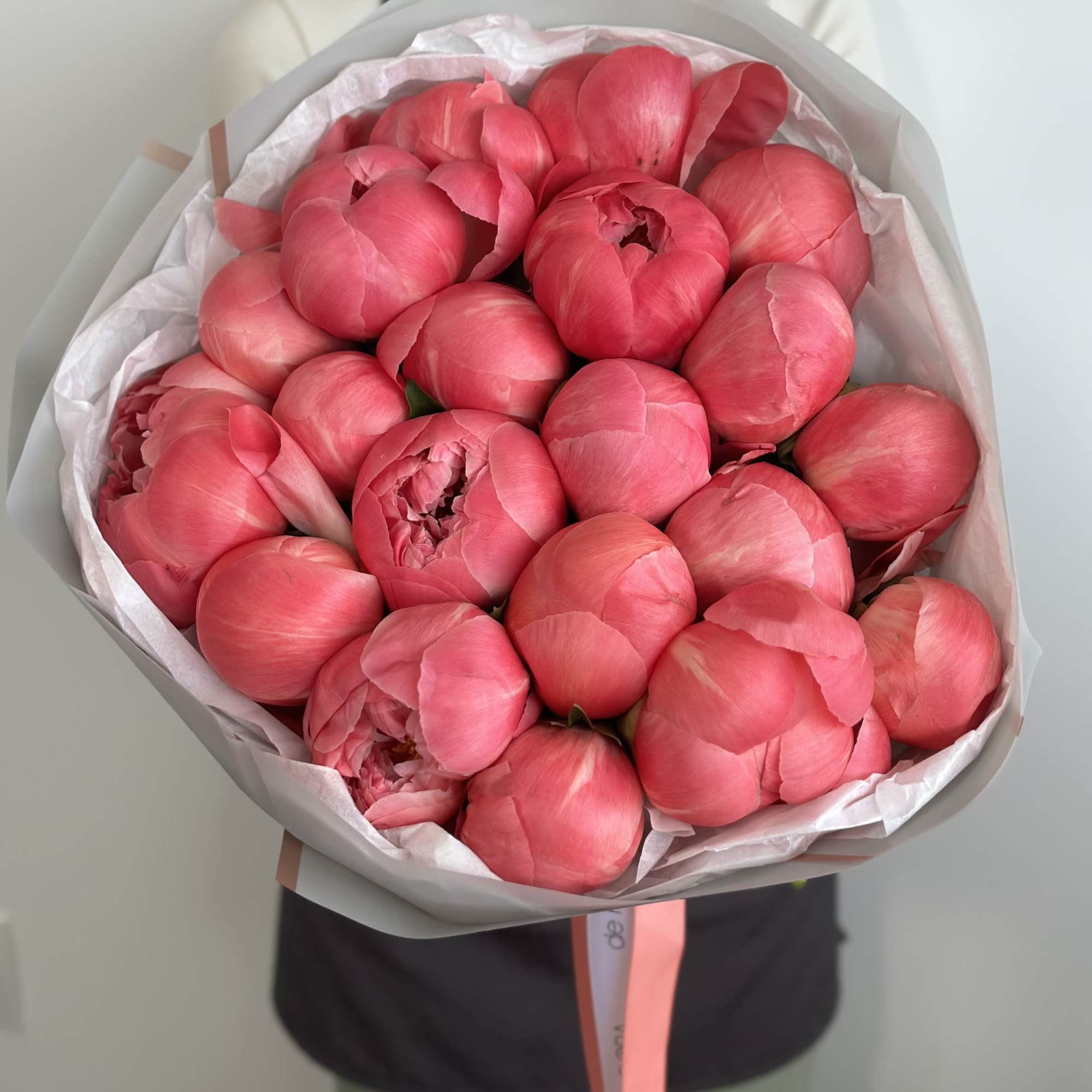 Bouquet of pink peonies wrapped in white paper