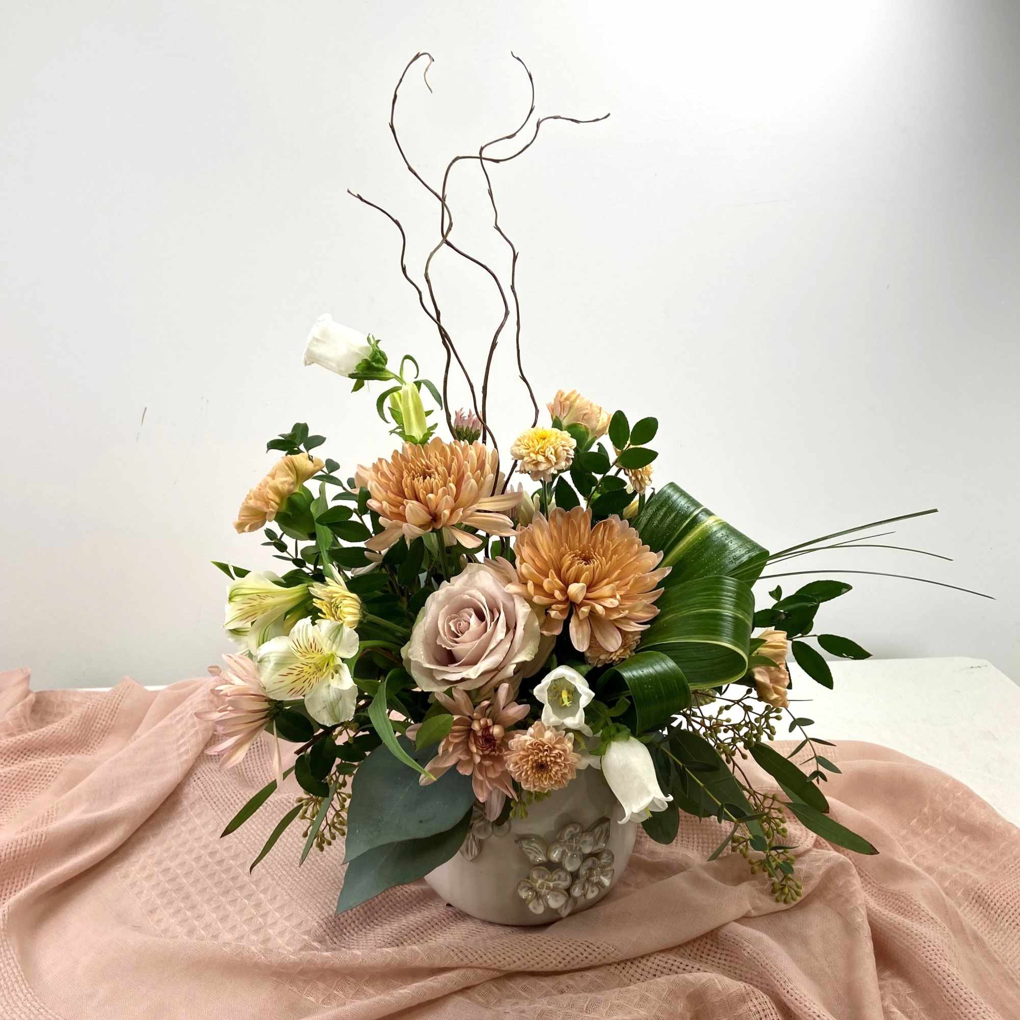 Soft peach and blush mingle with large creamy chrysanthemums to create a