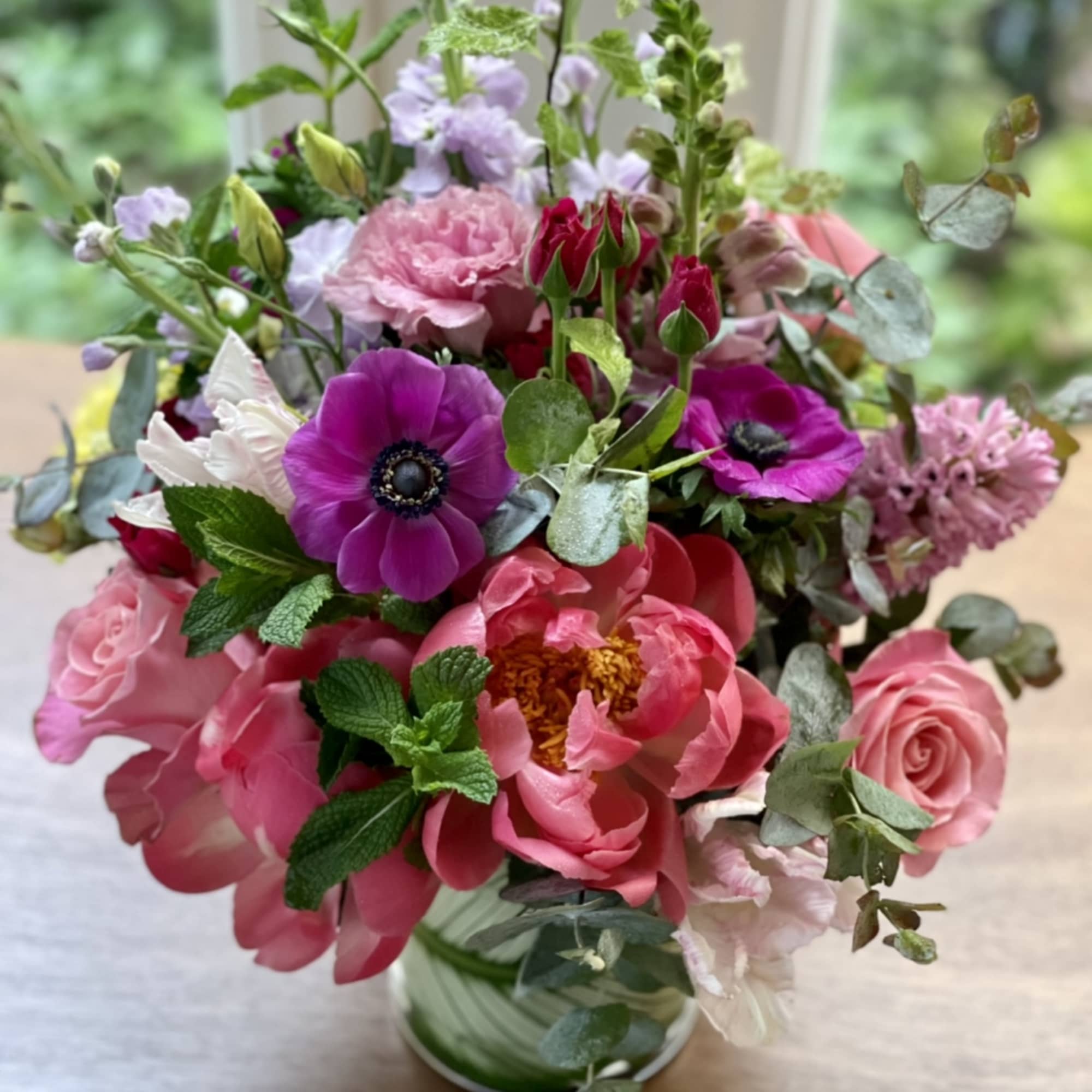 Pink and purple mixed flower arrangement in a glass vase