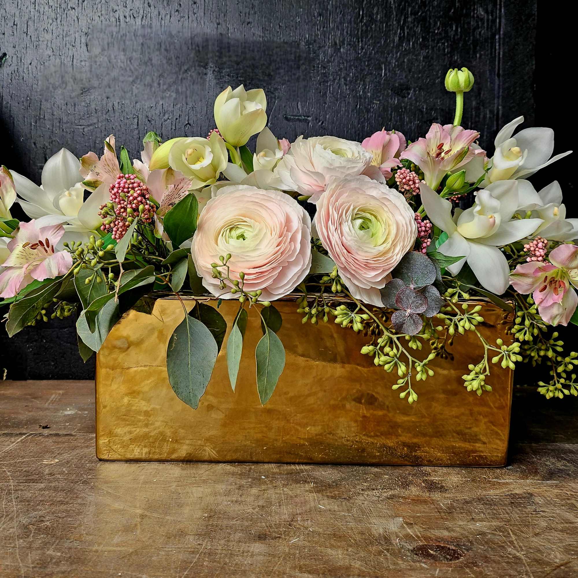 Pastel floral arrangement in a gold rectangular container