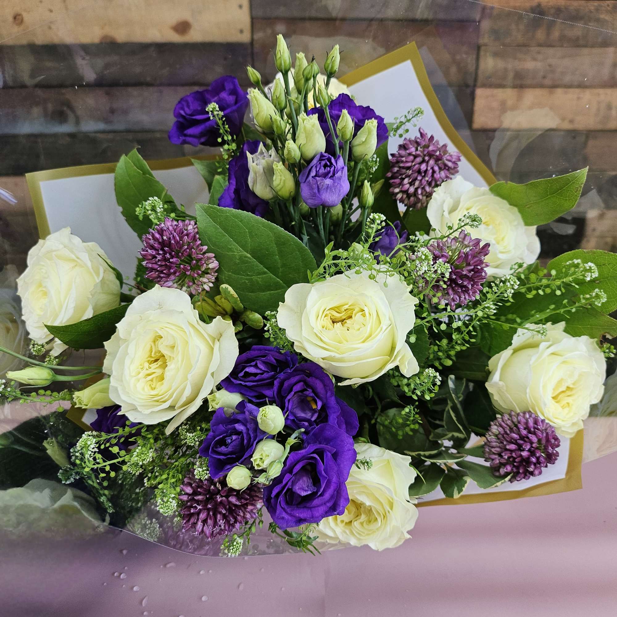 Bouquet of white roses and purple lisianthus with small purple allium blooms