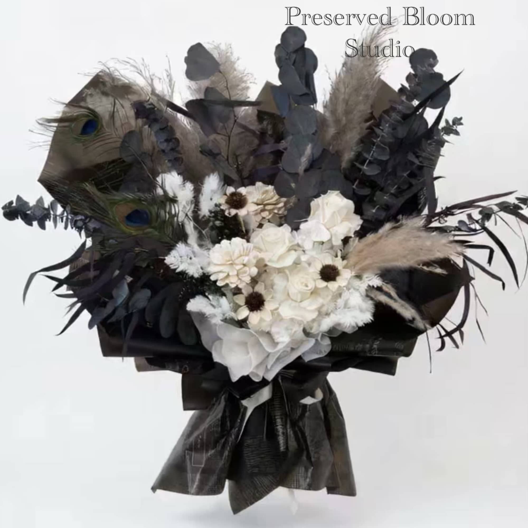 Dark bouquet with white flowers, peacock feathers, and black foliage