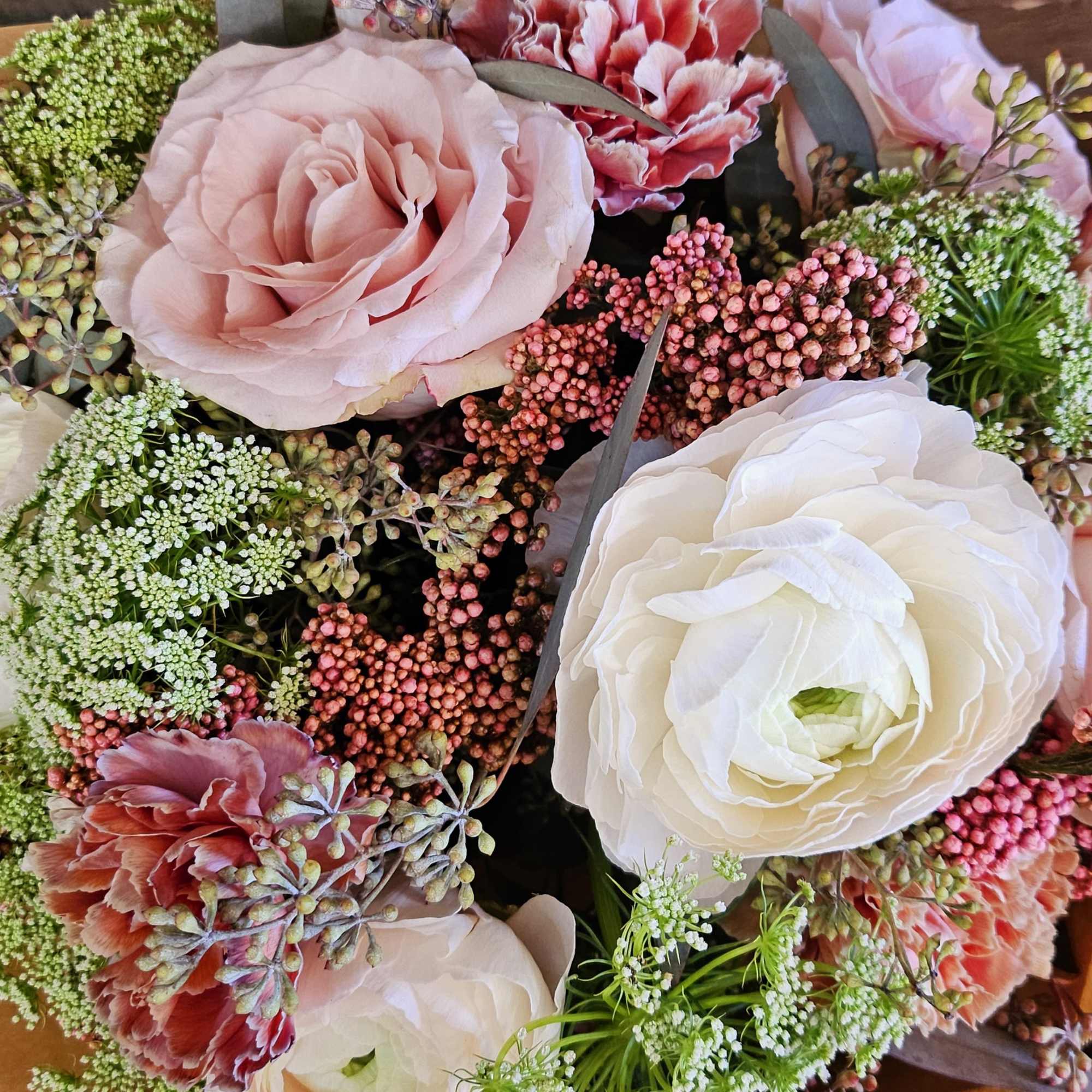 Bouquet of pale pink and white ranunculus with small filler flowers