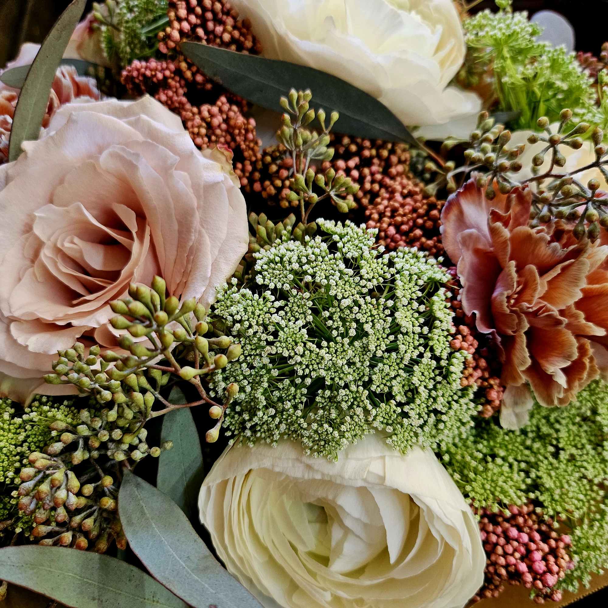 Bouquet of blush and white roses with textured filler flowers