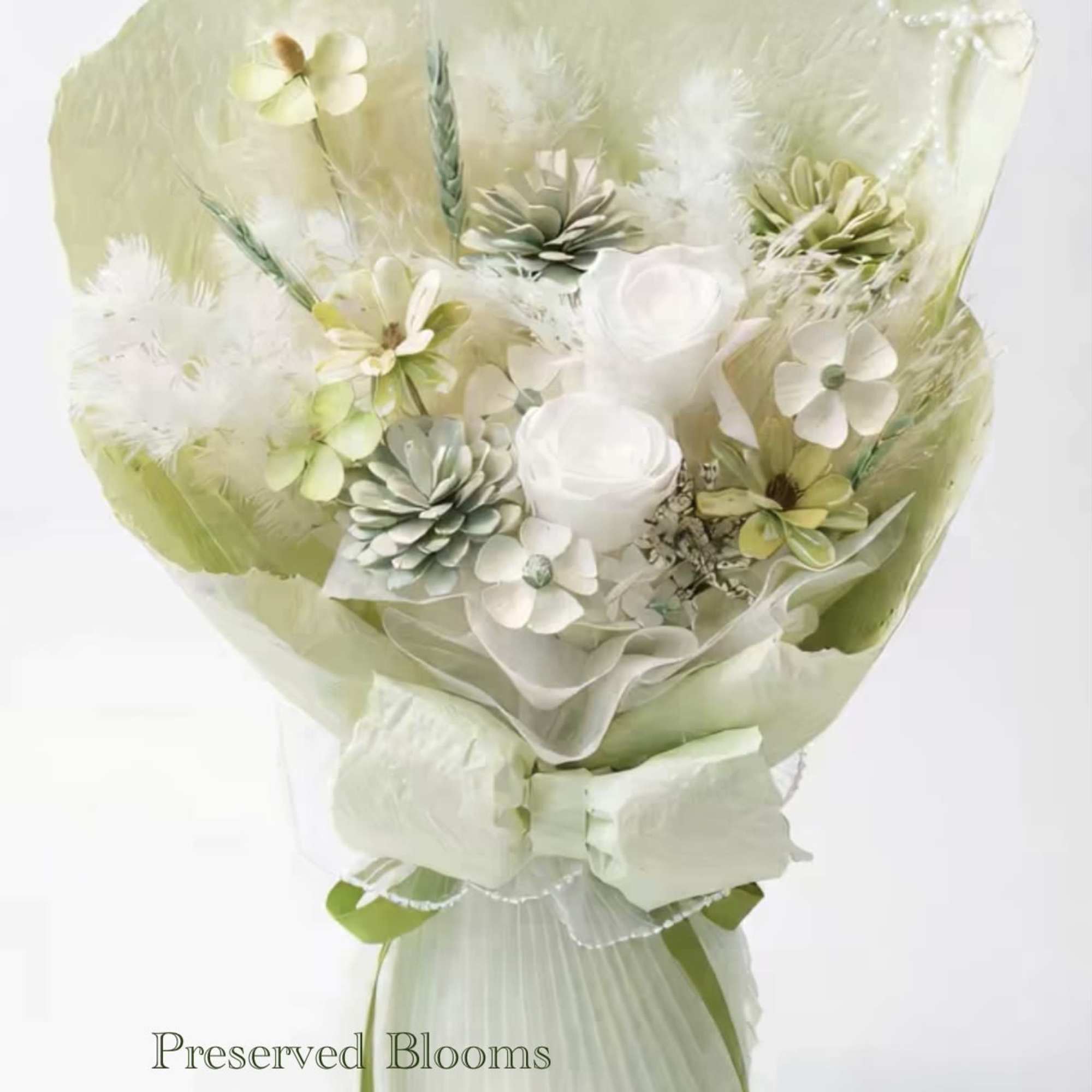 Pale green and white preserved bouquet with roses, small blossoms, and feathers wrapped in matching paper and bow