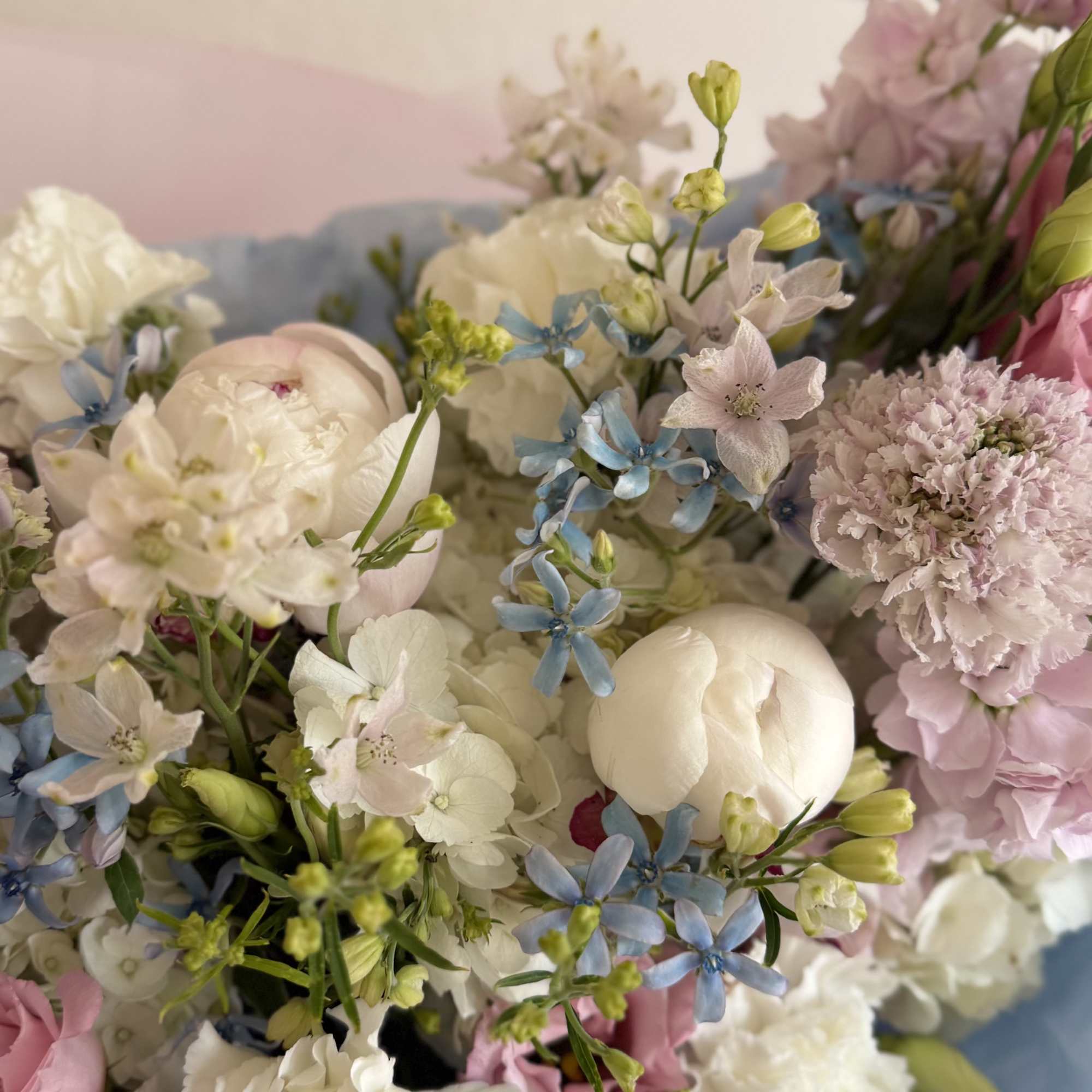 Soft pastel blooms gathered in a loose, hand-tied shape-this flower arrangement is